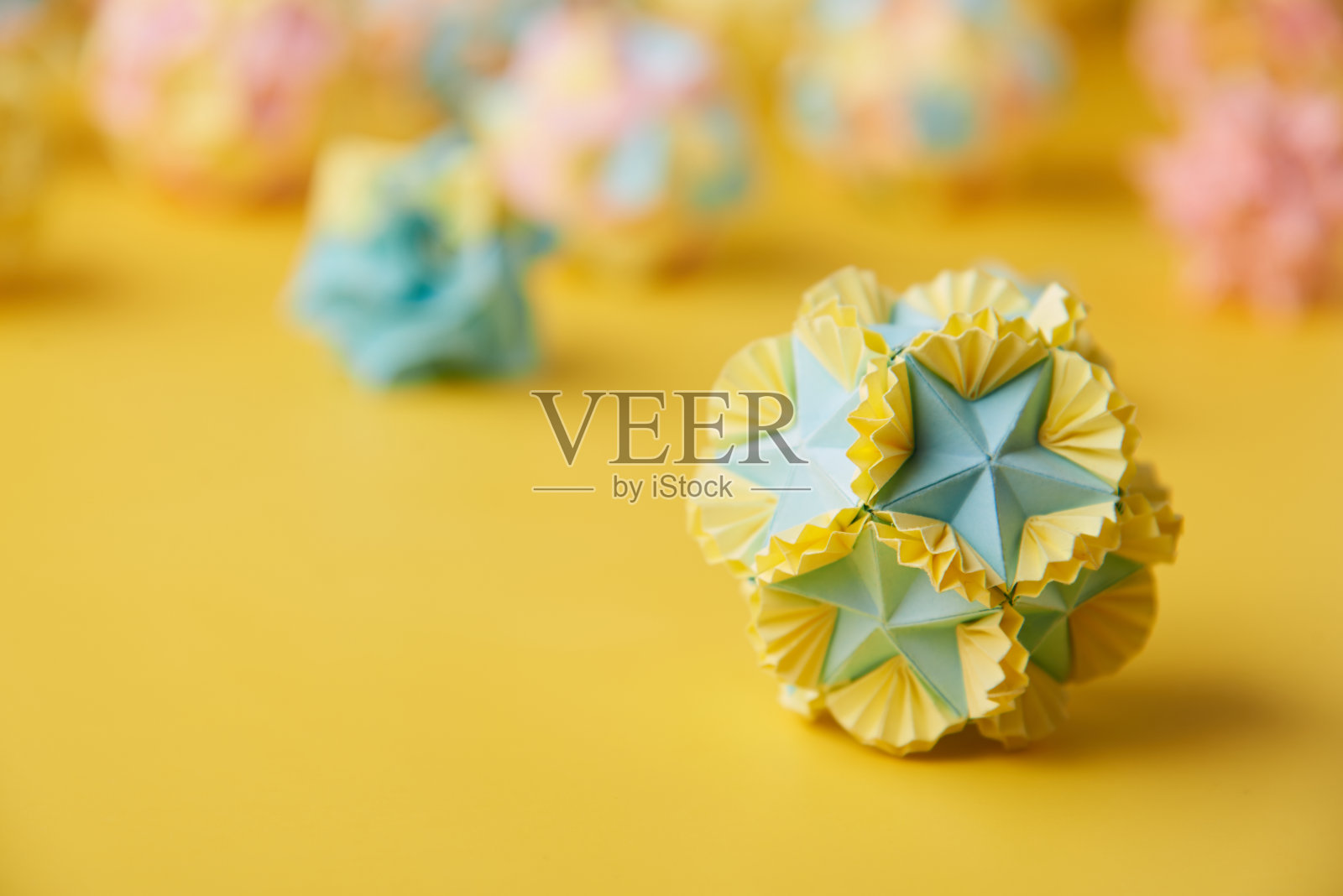 套multicolorÂ手工modularÂ折纸球或Kusudama孤立在黄色背景。视觉艺术，几何，折纸艺术，纸工艺品。特写，选择性聚焦，复制空间。照片摄影图片