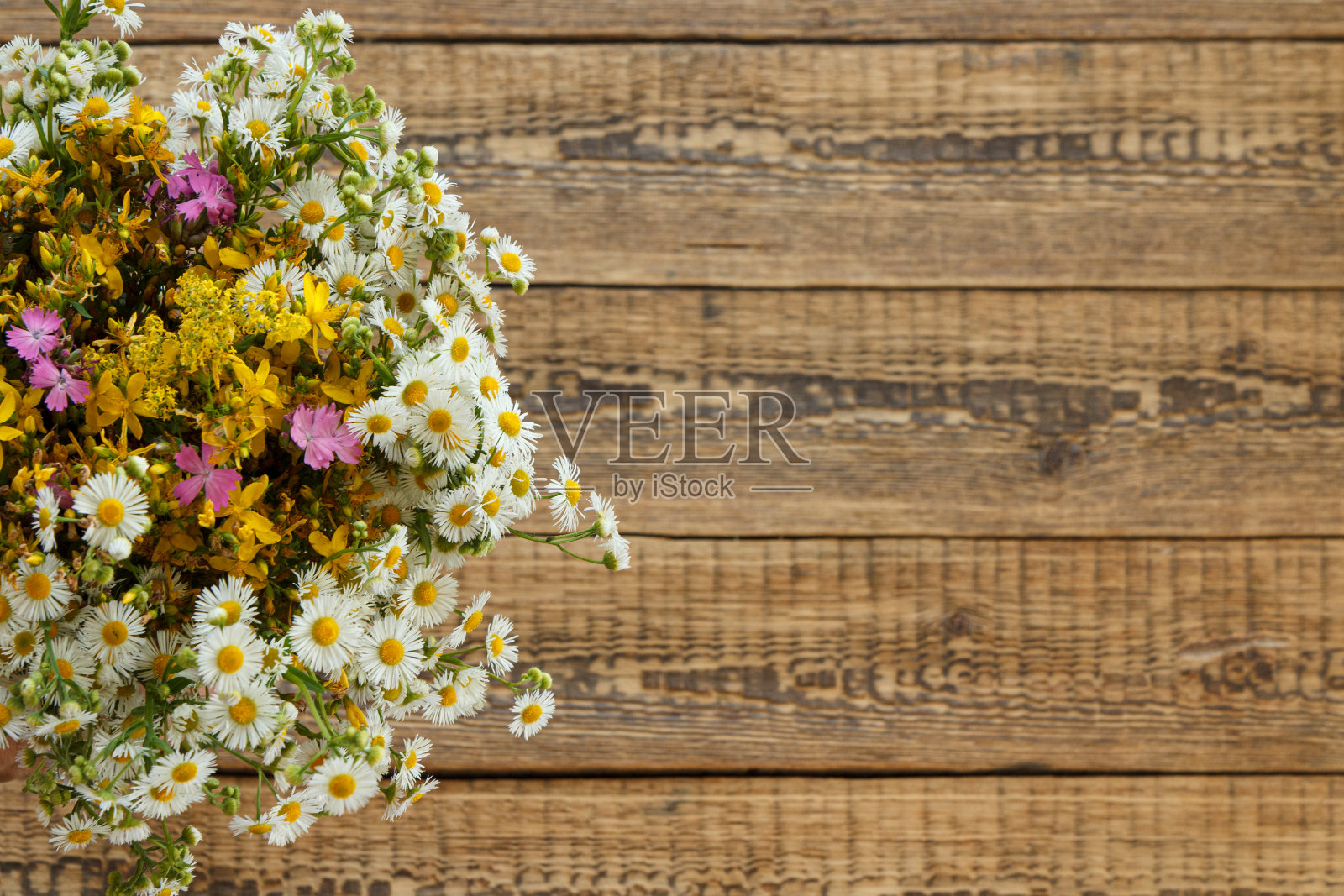 旧木板上的一束野花。照片摄影图片