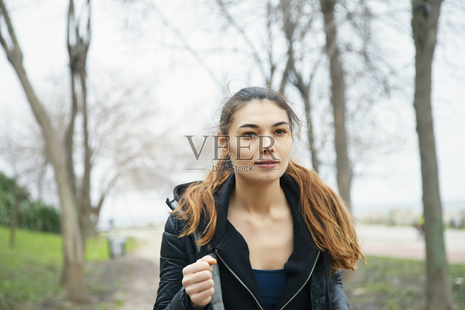 年轻的微笑积极有吸引力的女运动员在早上在公共公园跑步。照片摄影图片