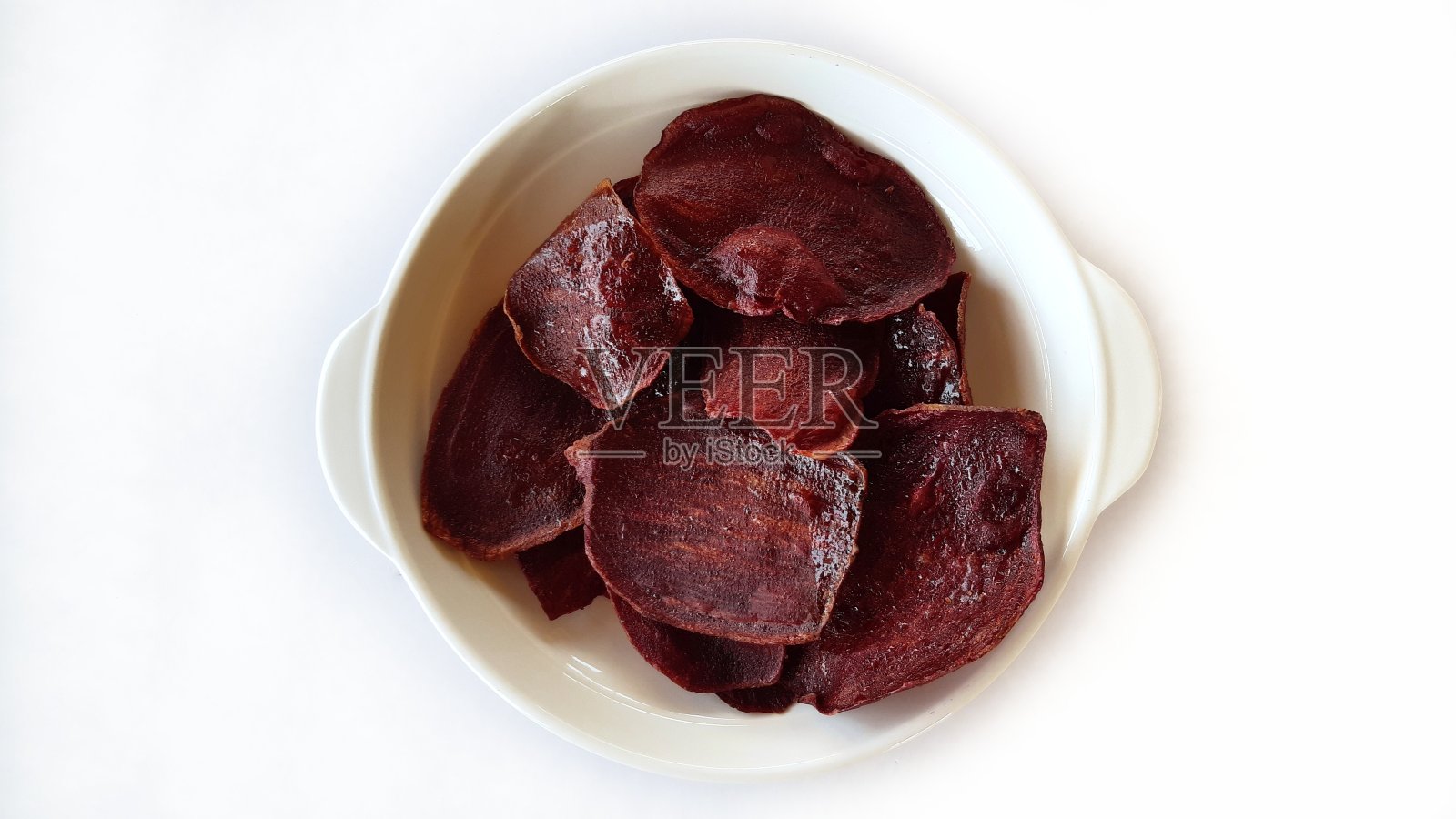 白色背景上的紫色土豆片。照片摄影图片