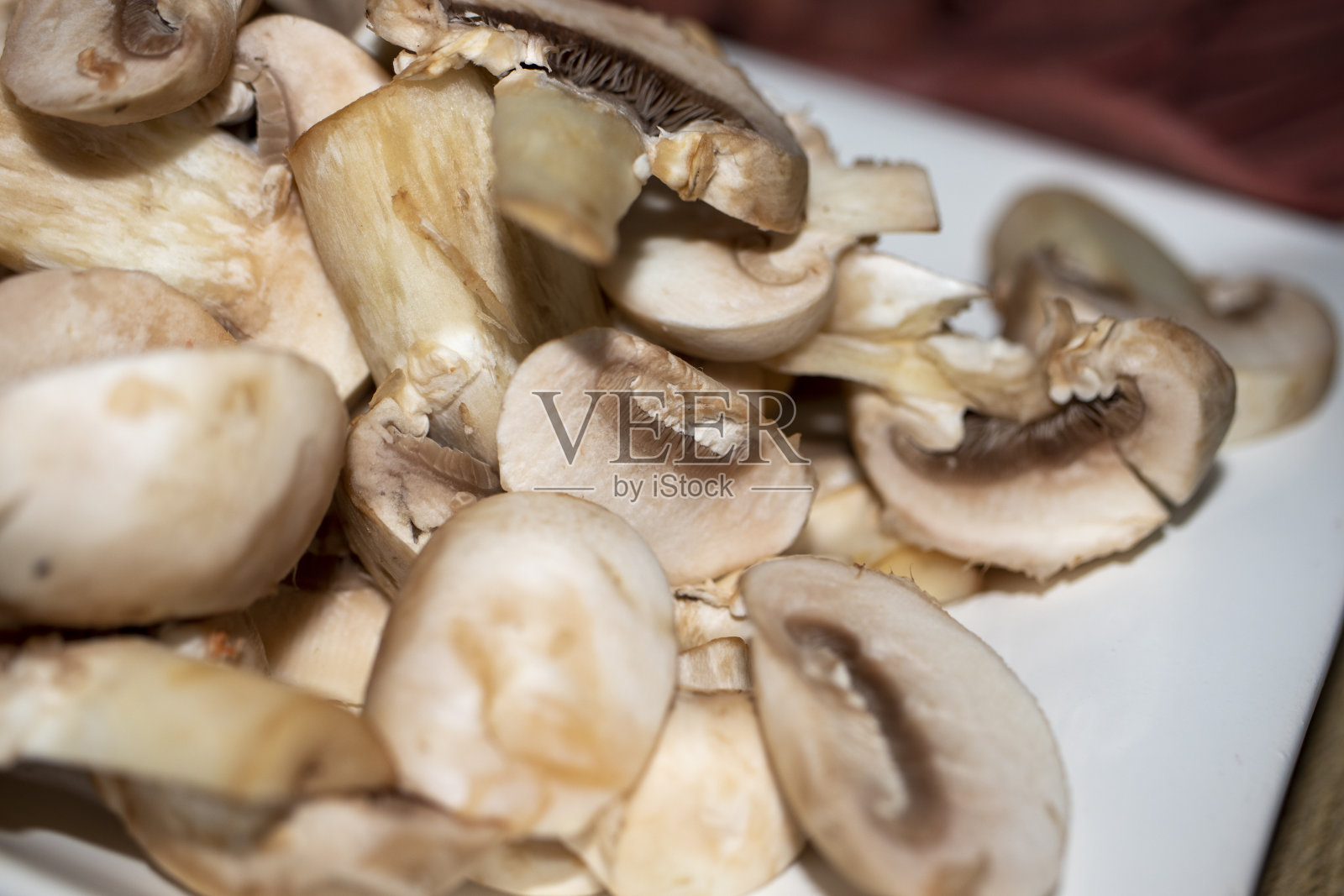 近距离清洗切碎的栽培蘑菇，准备烹饪。照片摄影图片