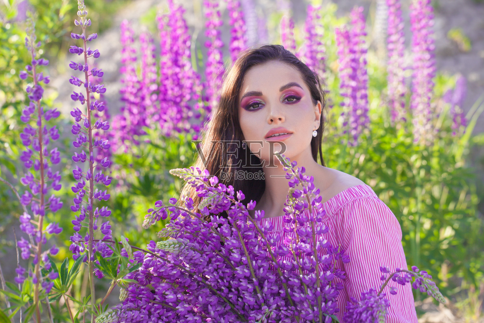夏天的美丽。可爱的黑发女子与彩色的鲜花肖像照片摄影图片