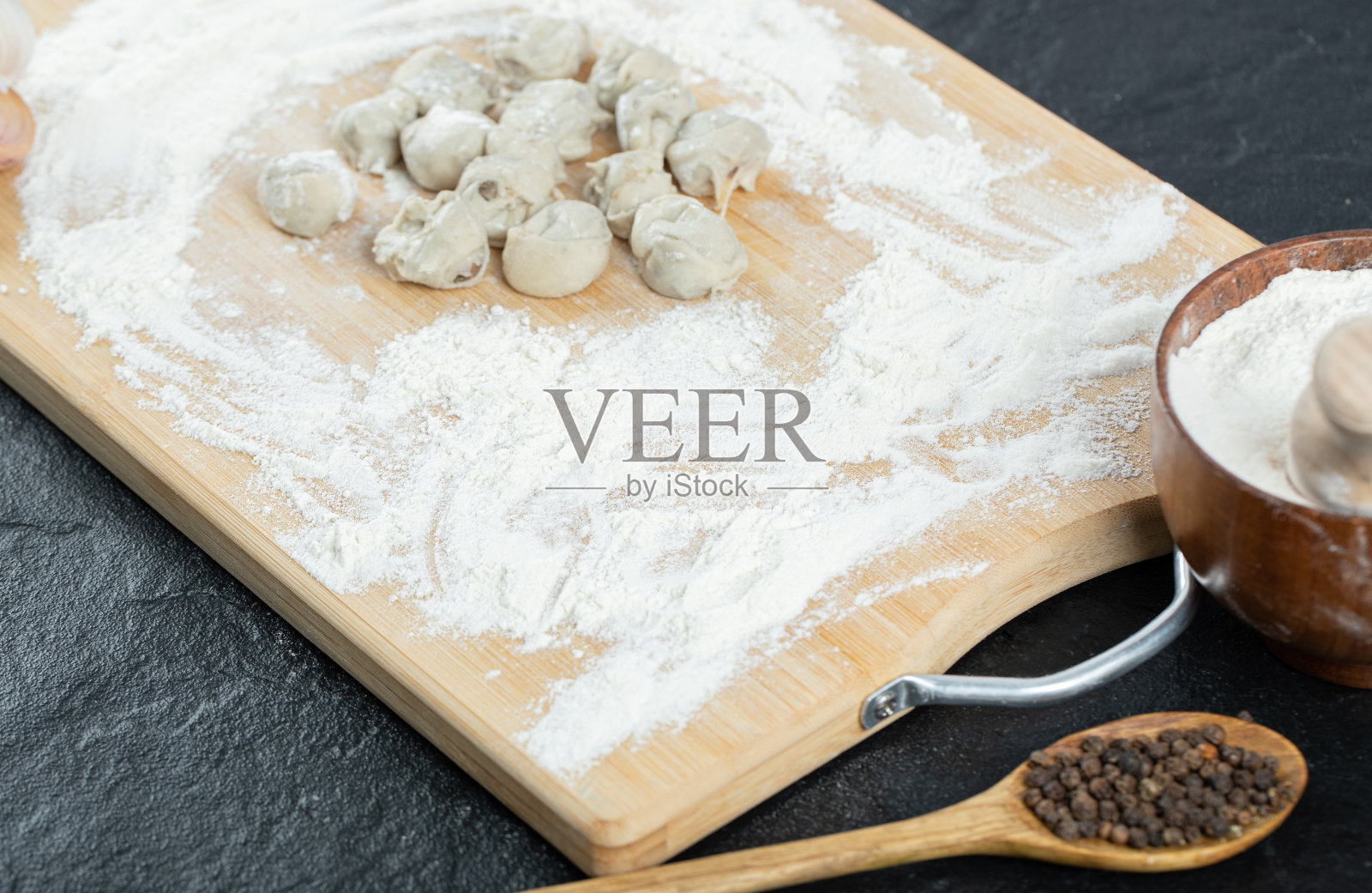 生饺子用面粉放在木板上照片摄影图片