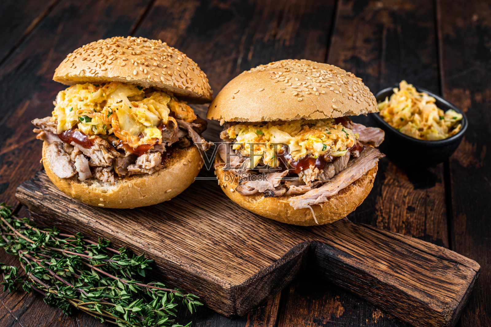 拉丝猪肉汉堡配烧烤酱和凉拌卷心菜沙拉。深色木制背景。俯视图照片摄影图片