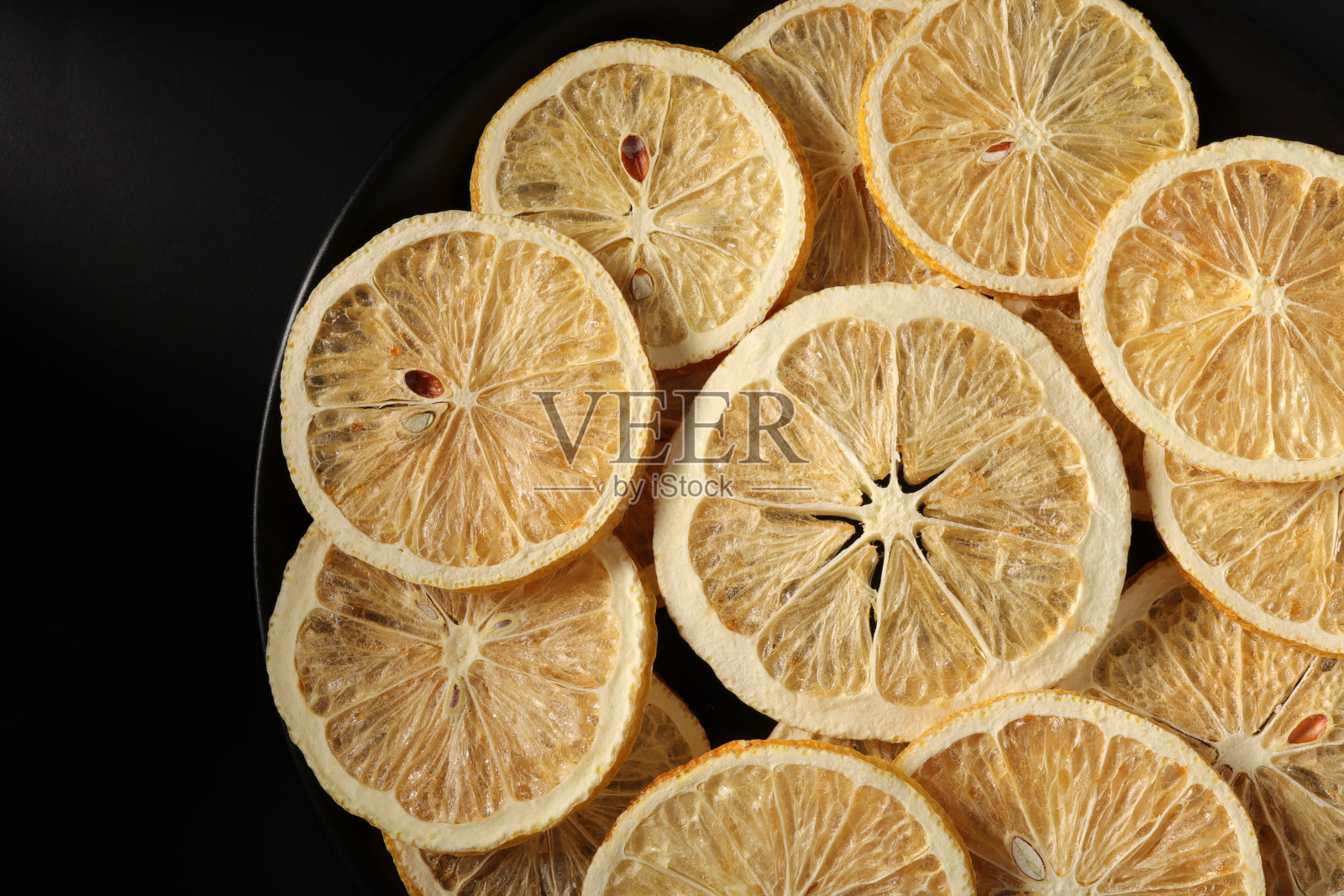 干柠檬片在一个黑色的盘子照片摄影图片
