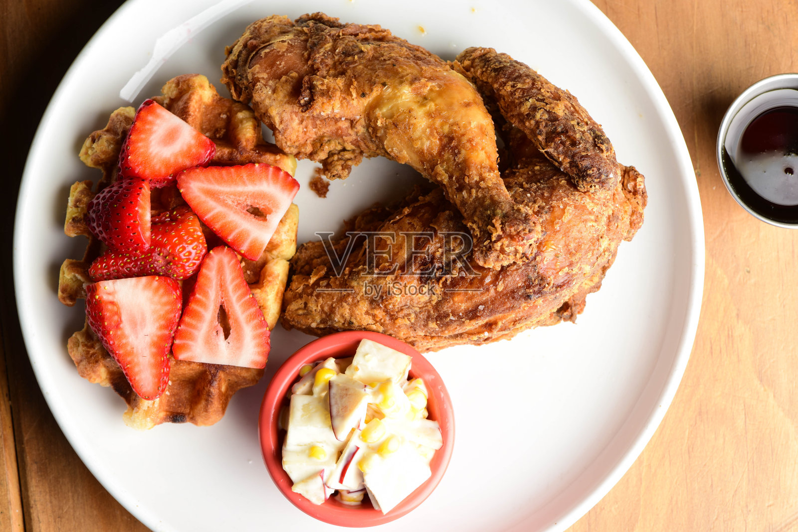鸡和蛋奶烘饼。脆脆的自制炸鸡配上自制的白脱牛奶华夫饼，再淋上黄油和枫糖浆。经典美国餐车风格的早餐或早午餐菜单项目。照片摄影图片