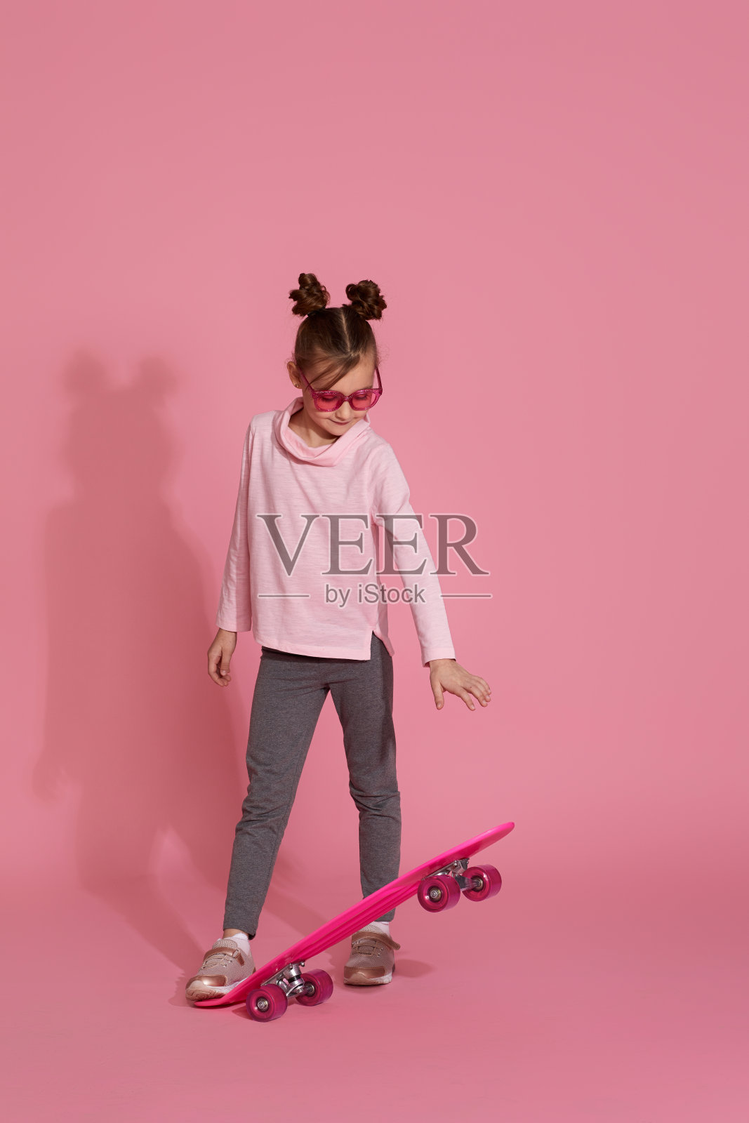 带着粉色滑板的小女孩照片摄影图片