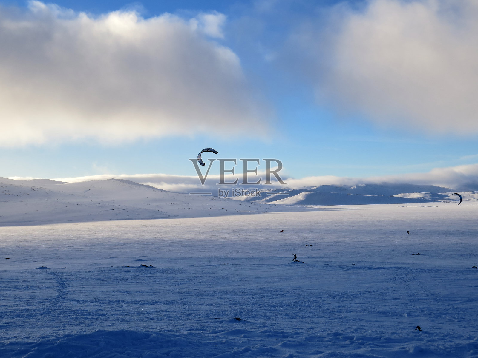 雪风筝在一个阳光明媚的冬日照片摄影图片