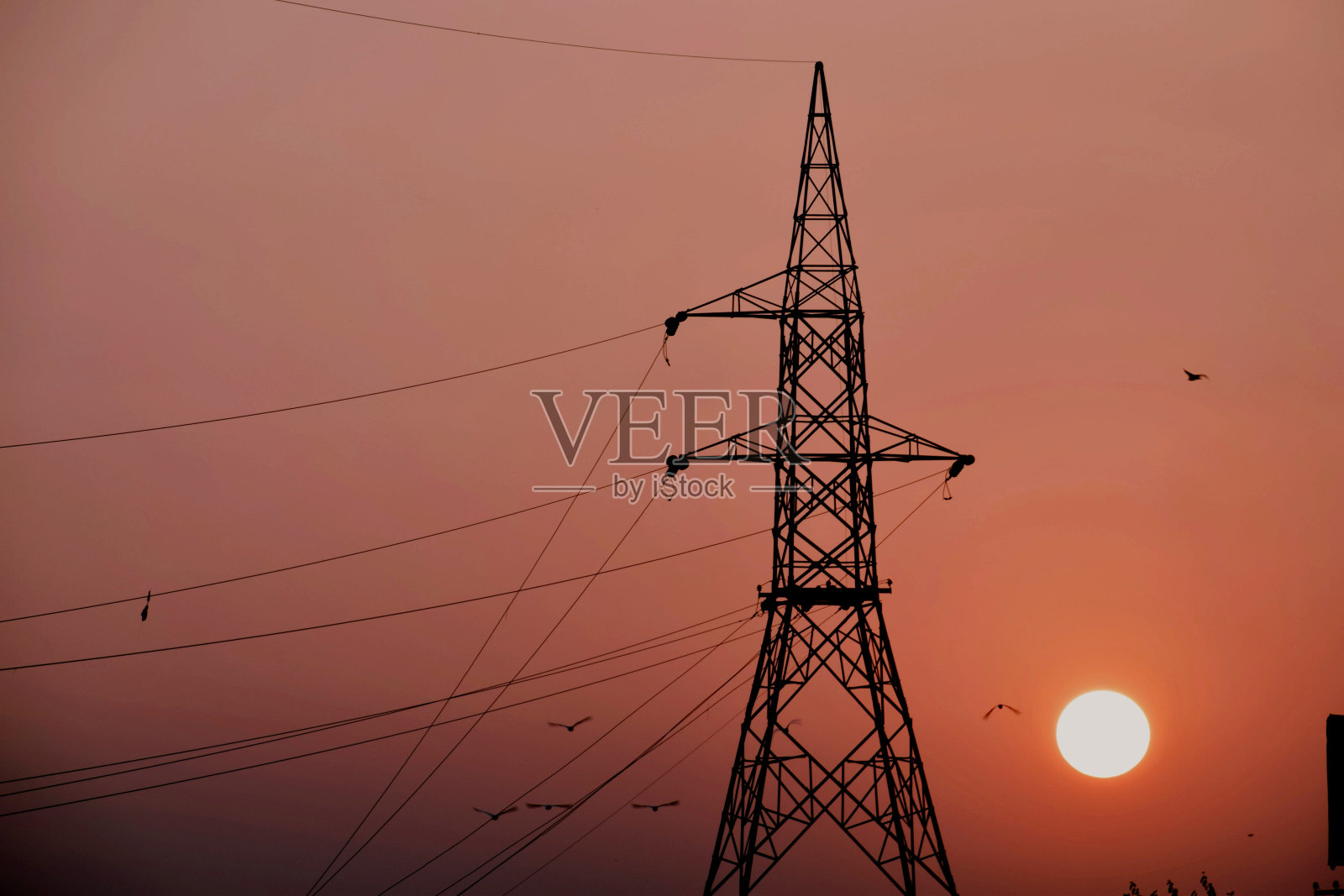 美丽的大电力塔和大橙色太阳的背景。选择性关注学科照片摄影图片