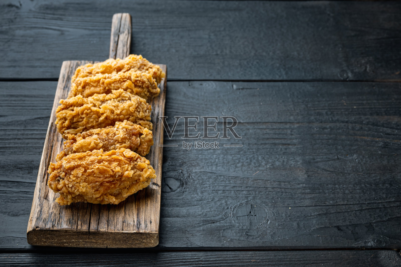 炸鸡翅上的黑色木制背景，有文字空间照片摄影图片