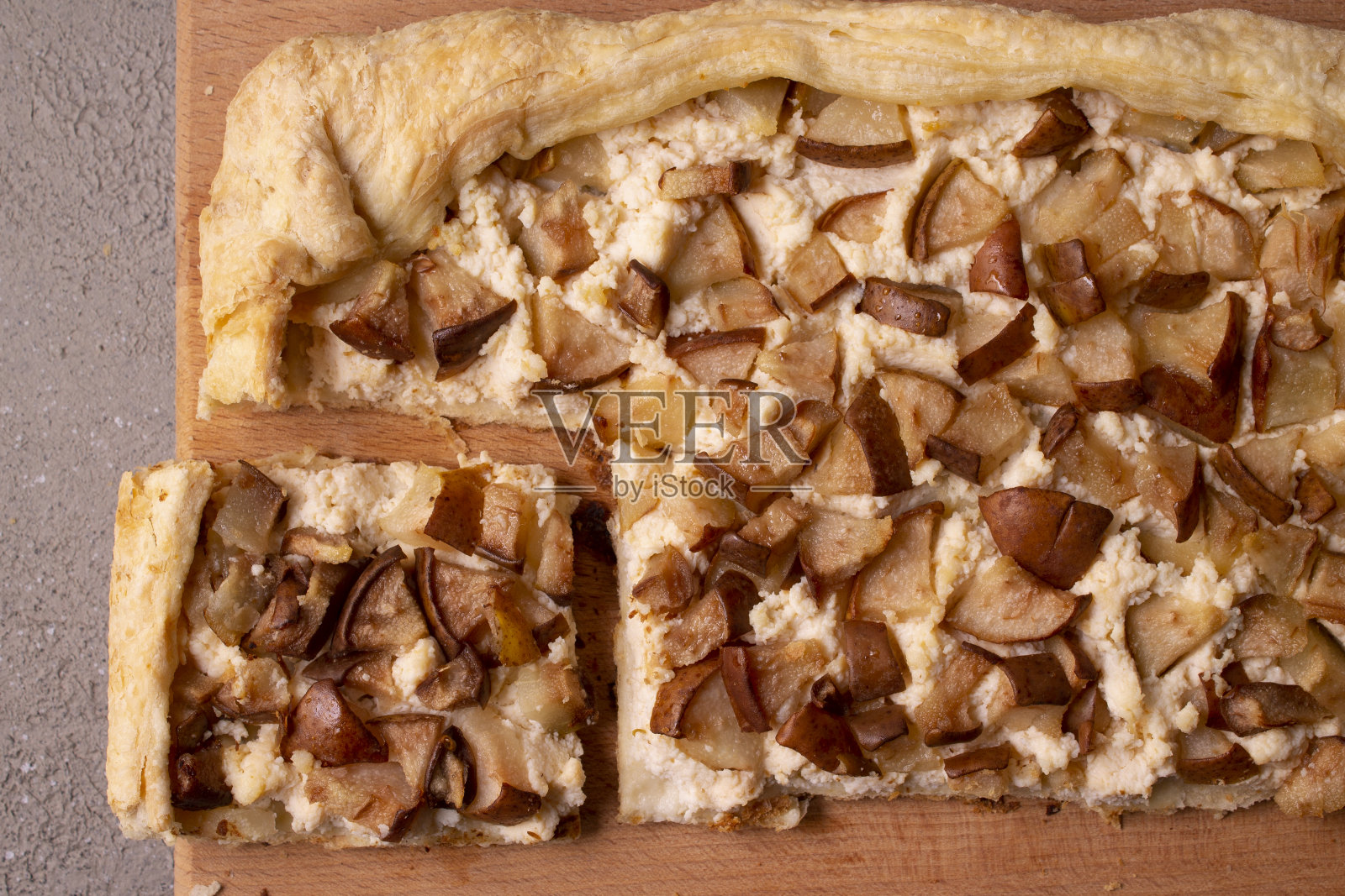 在木板上放有乳清干酪和梨的派。平的。照片摄影图片