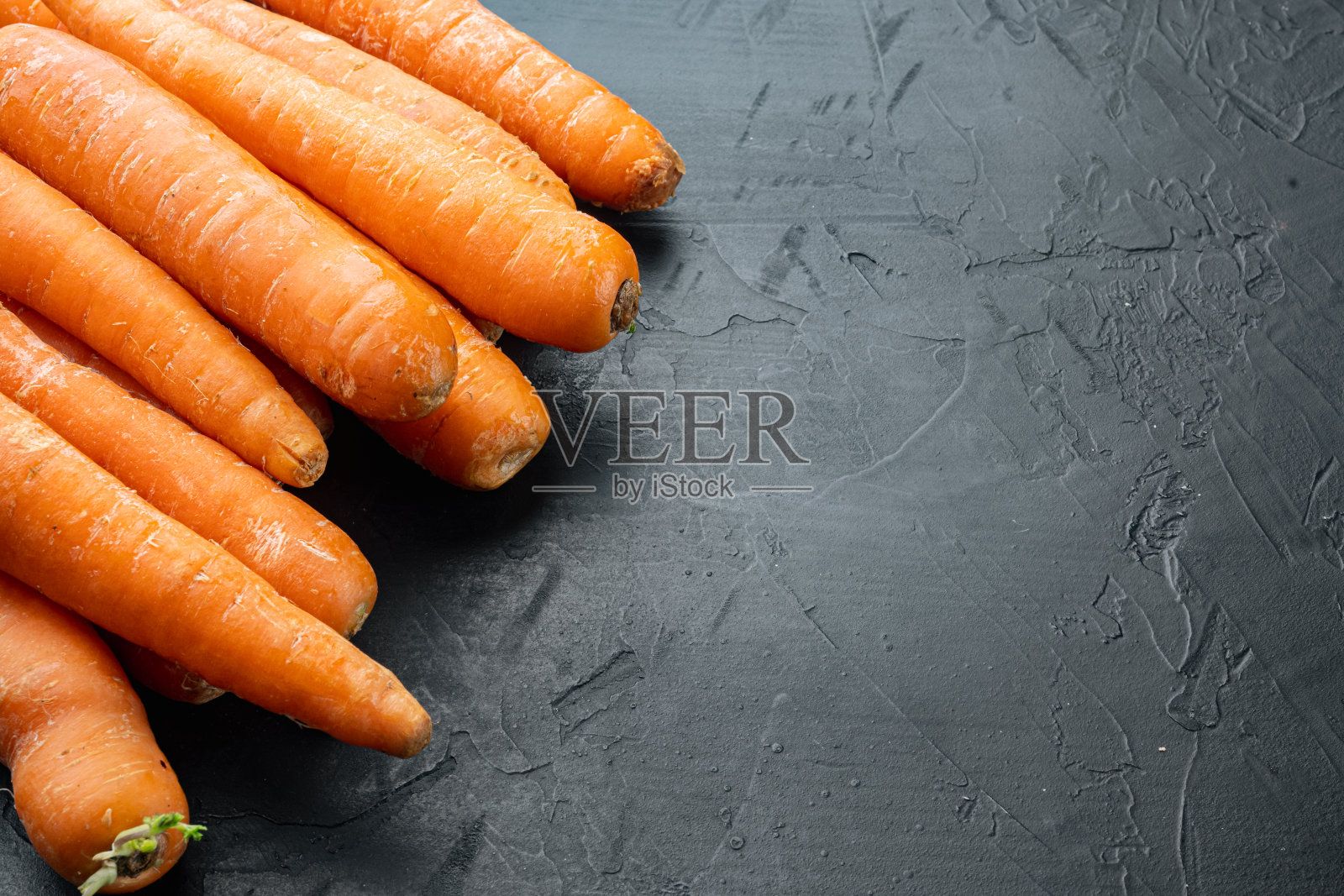 串彩色橙色胡萝卜，在黑色的背景，与copyspace和文本空间照片摄影图片