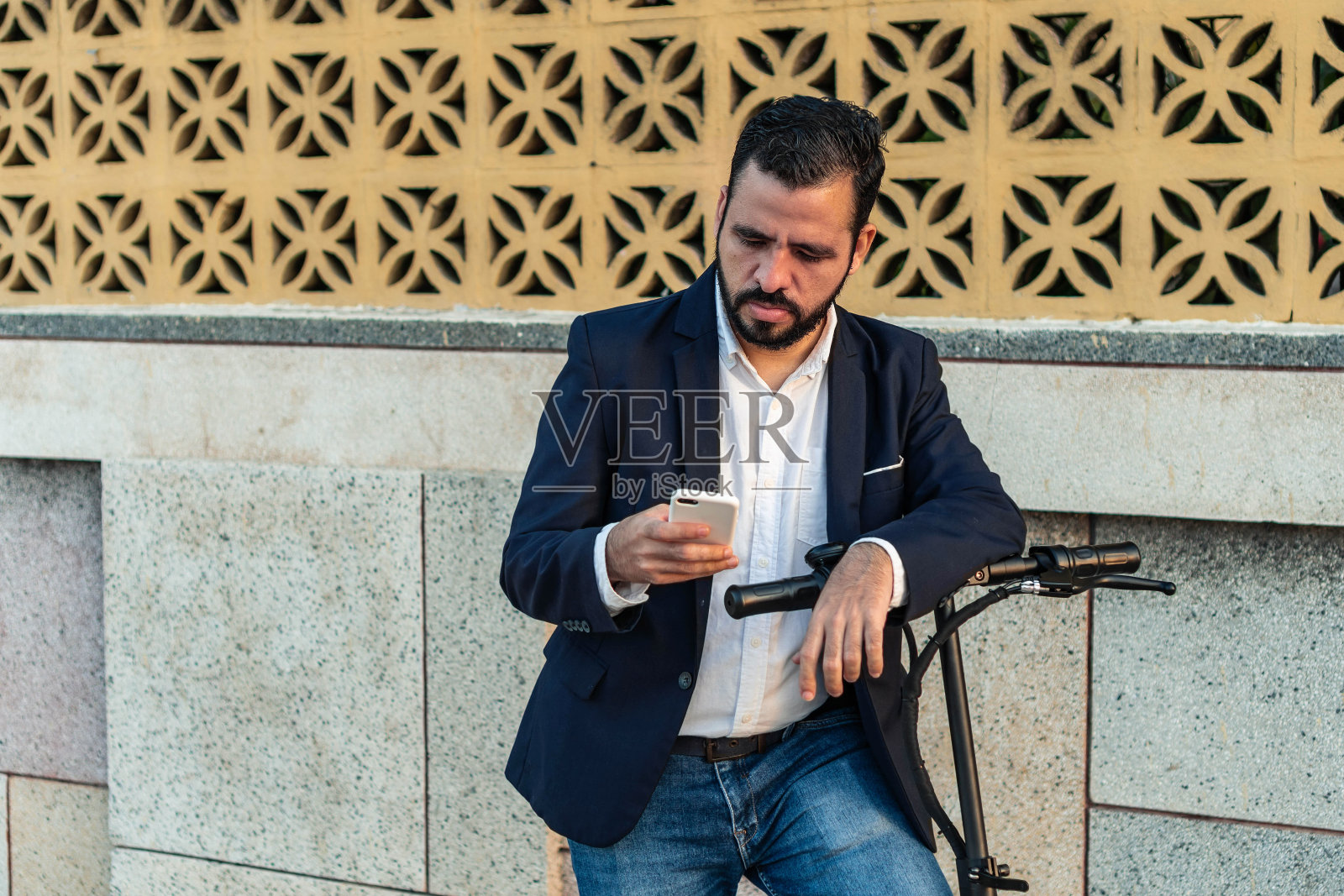 一个留着胡子开着摩托车的男人在看手机照片摄影图片