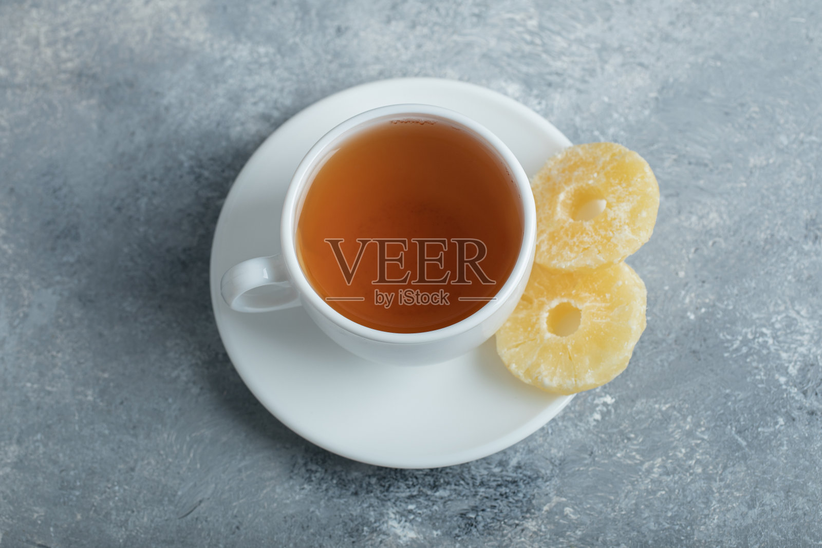 一杯在黑色背景上放着干菠萝的香茶照片摄影图片