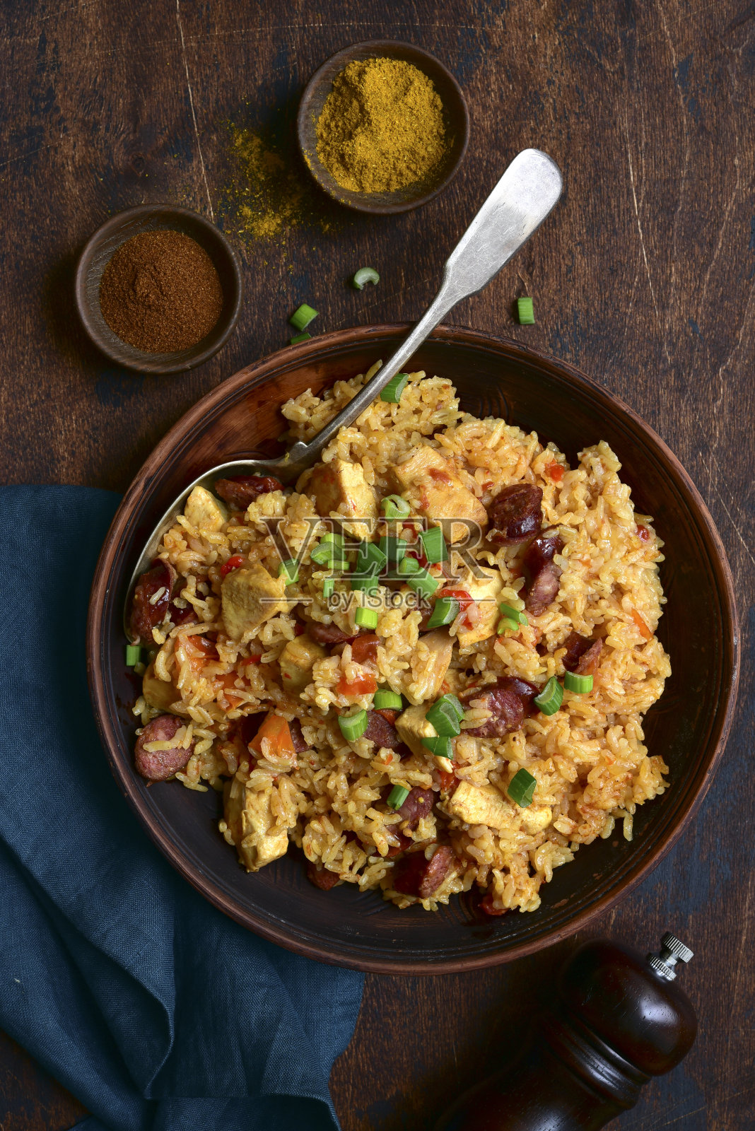 什锦饭——一碗辛辣的米饭，配上番茄、肉和烟熏香肠照片摄影图片