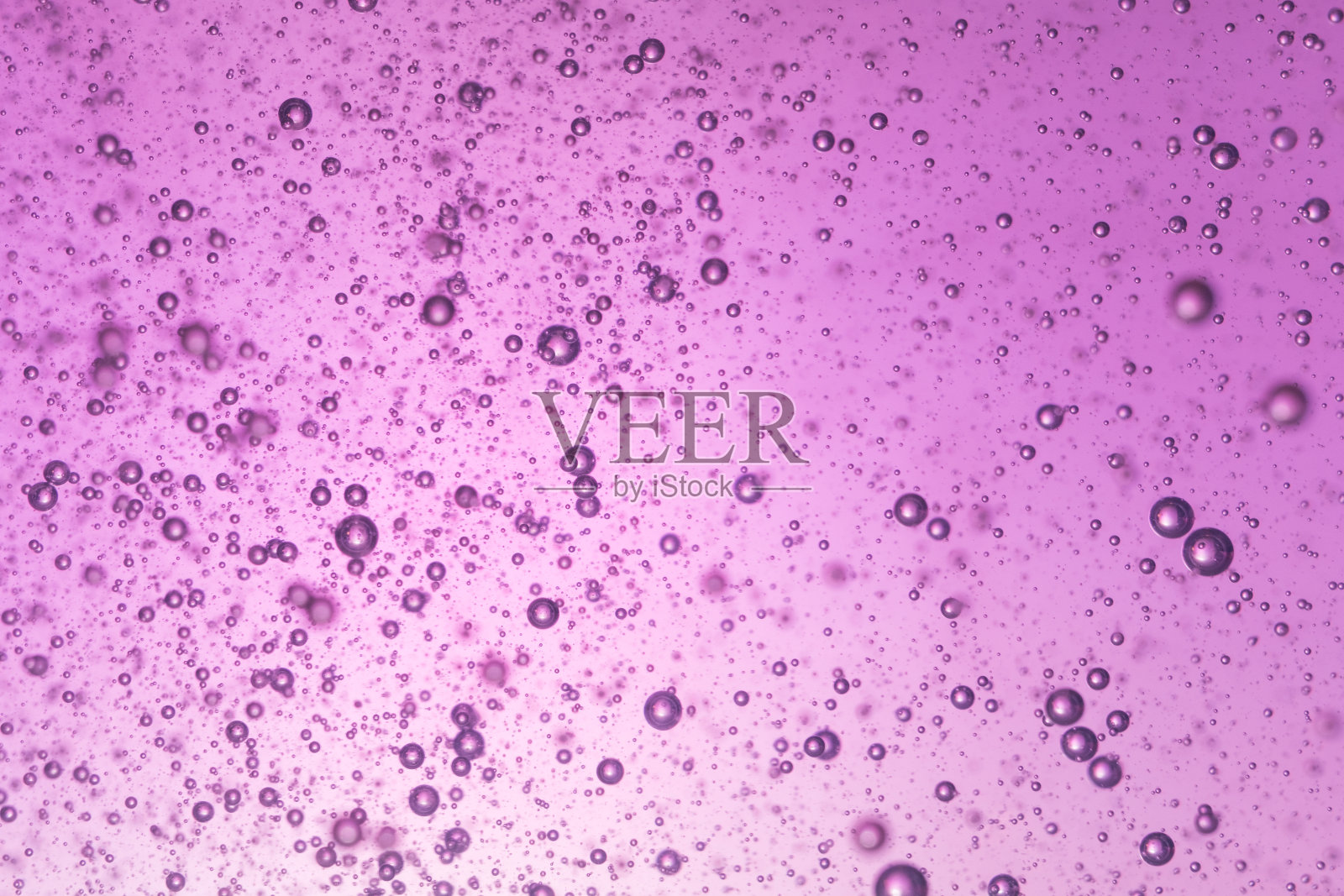 小气泡自由漂浮在透明的液体中，背景有光照片摄影图片