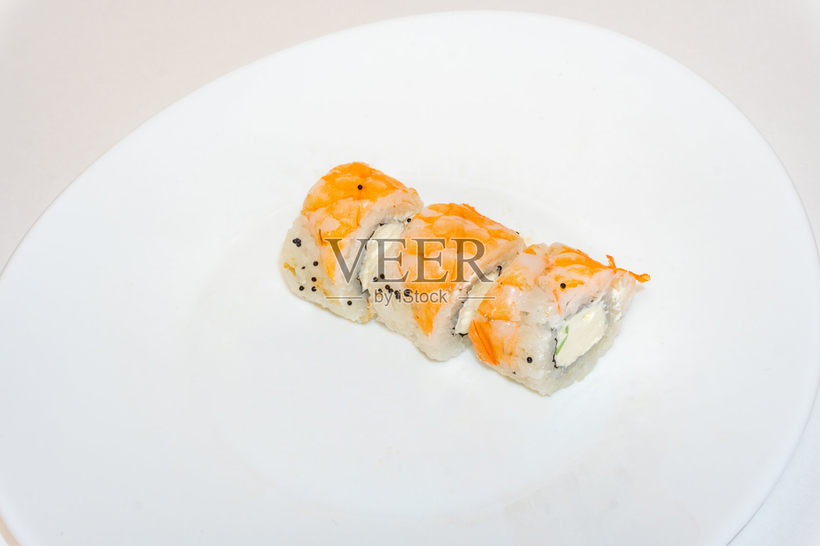 寿司卷、大虾和奶油芝士躺在白色的盘子里。日本厨房，欧洲寿司卷照片摄影图片