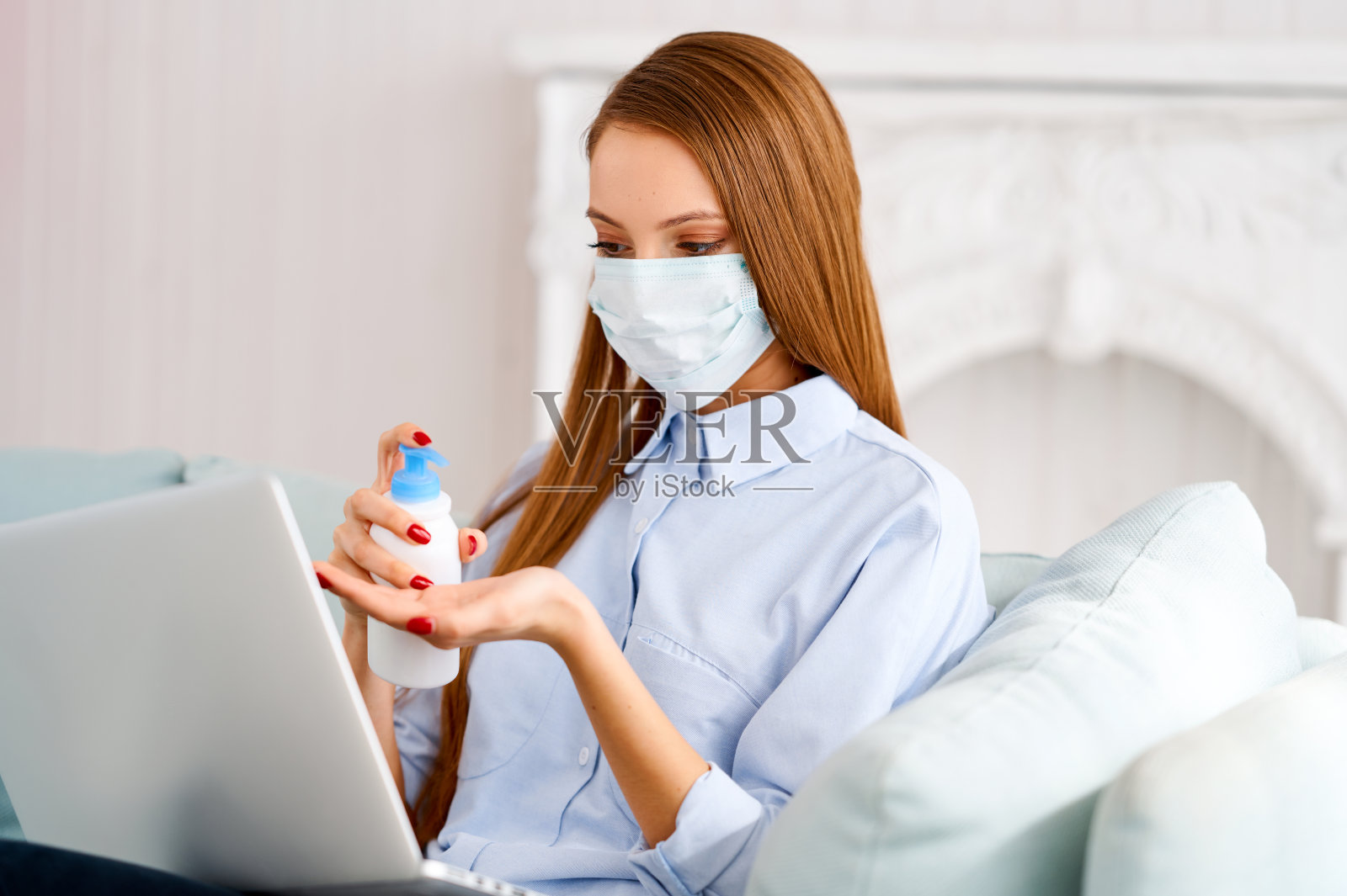 一名女性在使用笔记本电脑工作时使用抗菌杀菌凝胶消毒和清洁双手。手保护，防止病毒，细菌和细菌照片摄影图片