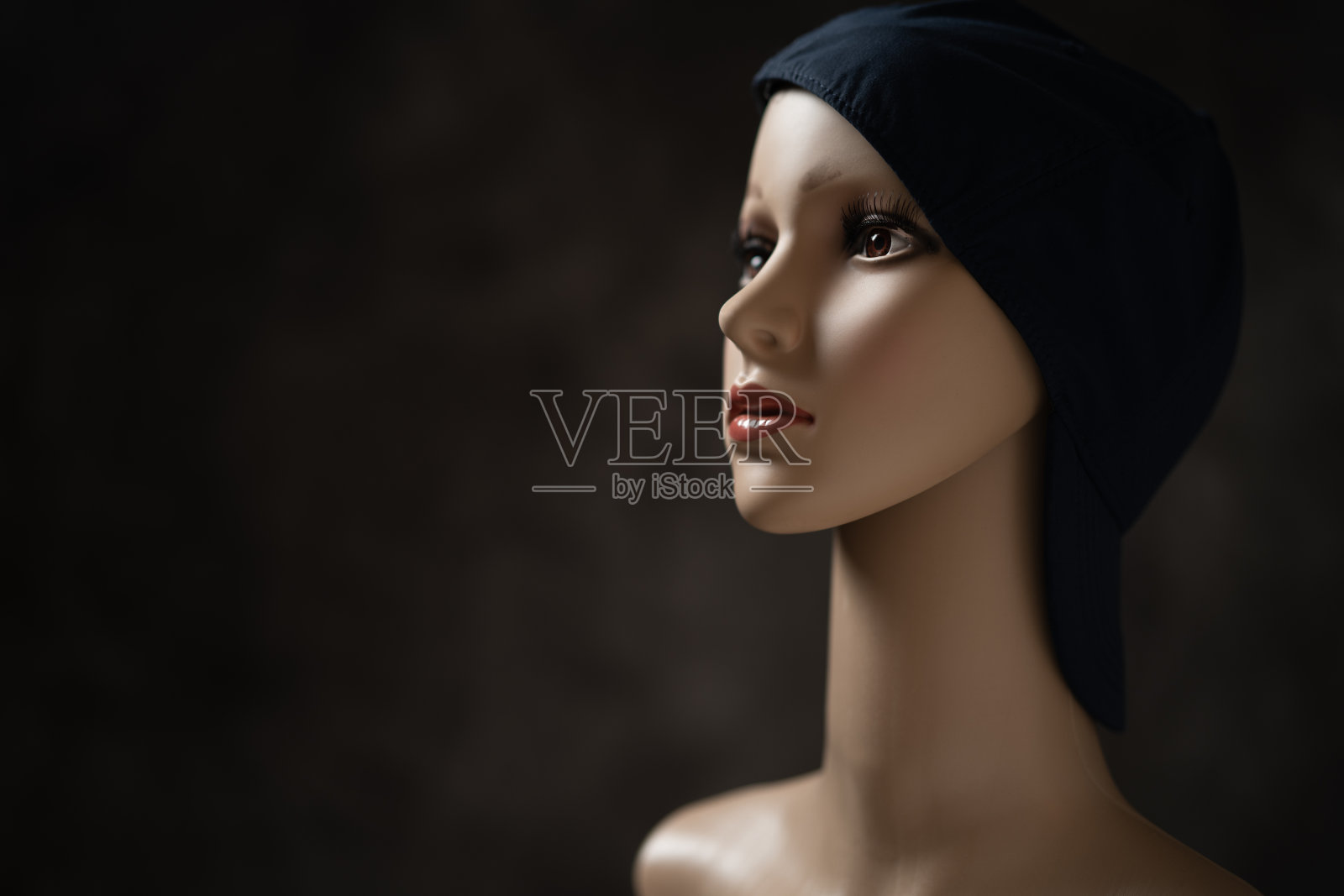 在黑色背景前戴着帽子的人体模型照片摄影图片