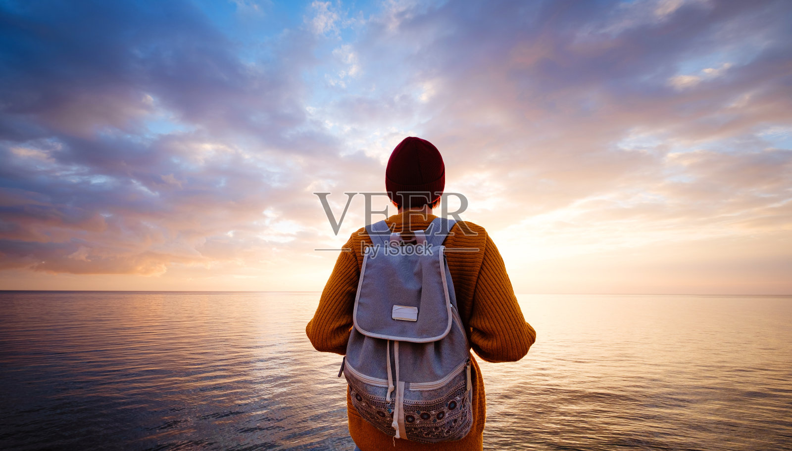 一位风平浪静的迷人年轻女子站在海边表达她的喜悦。照片摄影图片