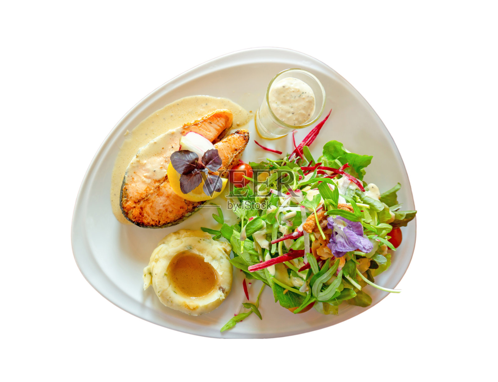 烤鲑鱼排切片在白色盘子与混合蔬菜沙拉，土豆泥和浇头在一个玻璃，食物在盘子孤立的白色背景与剪切路径和复制空间照片摄影图片