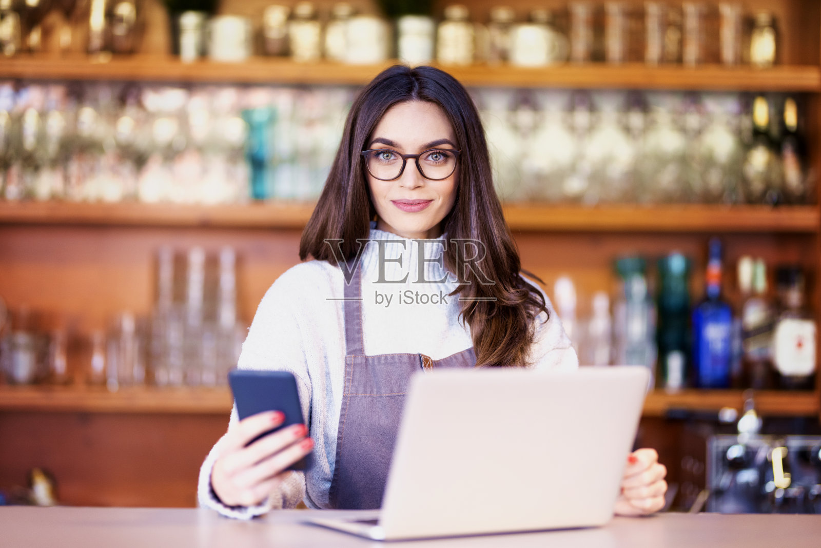 漂亮的女服务员站在柜台后面工作的肖像照片摄影图片