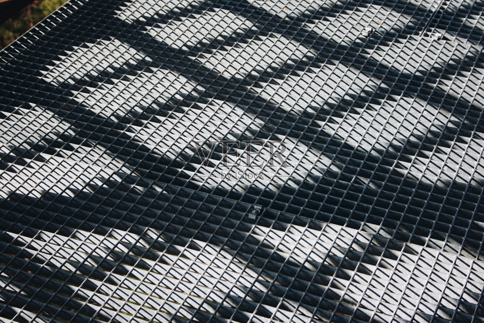 特写的金属栅栏与对角阴影。栅栏的阴影。照片摄影图片