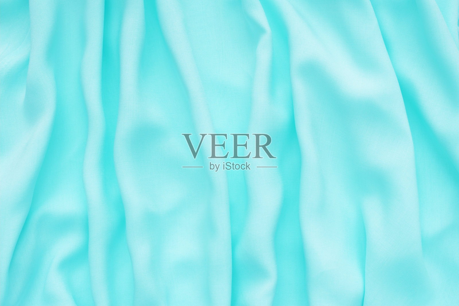 抽象的背景，丝绸质地豪华浅蓝色面料与波浪褶皱。照片摄影图片