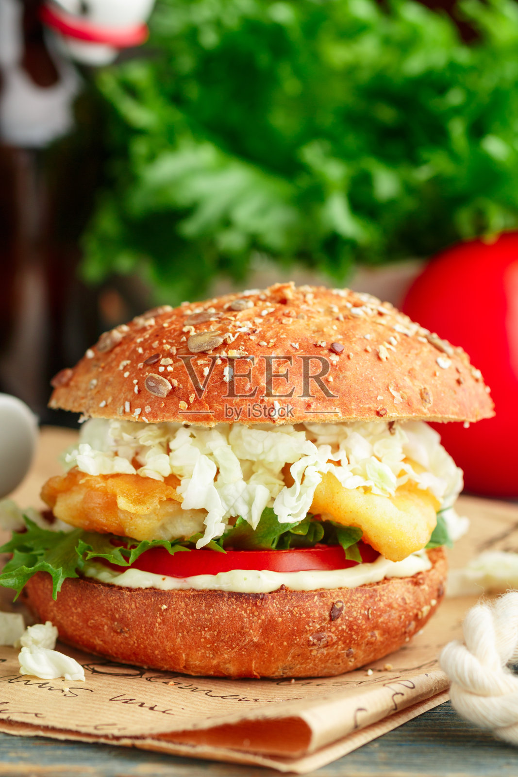 鱼汉堡。美味的汉堡配炸白鱼(鳕鱼，鳕鱼，鲈鱼，鳕鱼)，西红柿，生菜，卷心菜和鞑靼沙司全麦面包。快餐换啤酒。有选择性的重点照片摄影图片