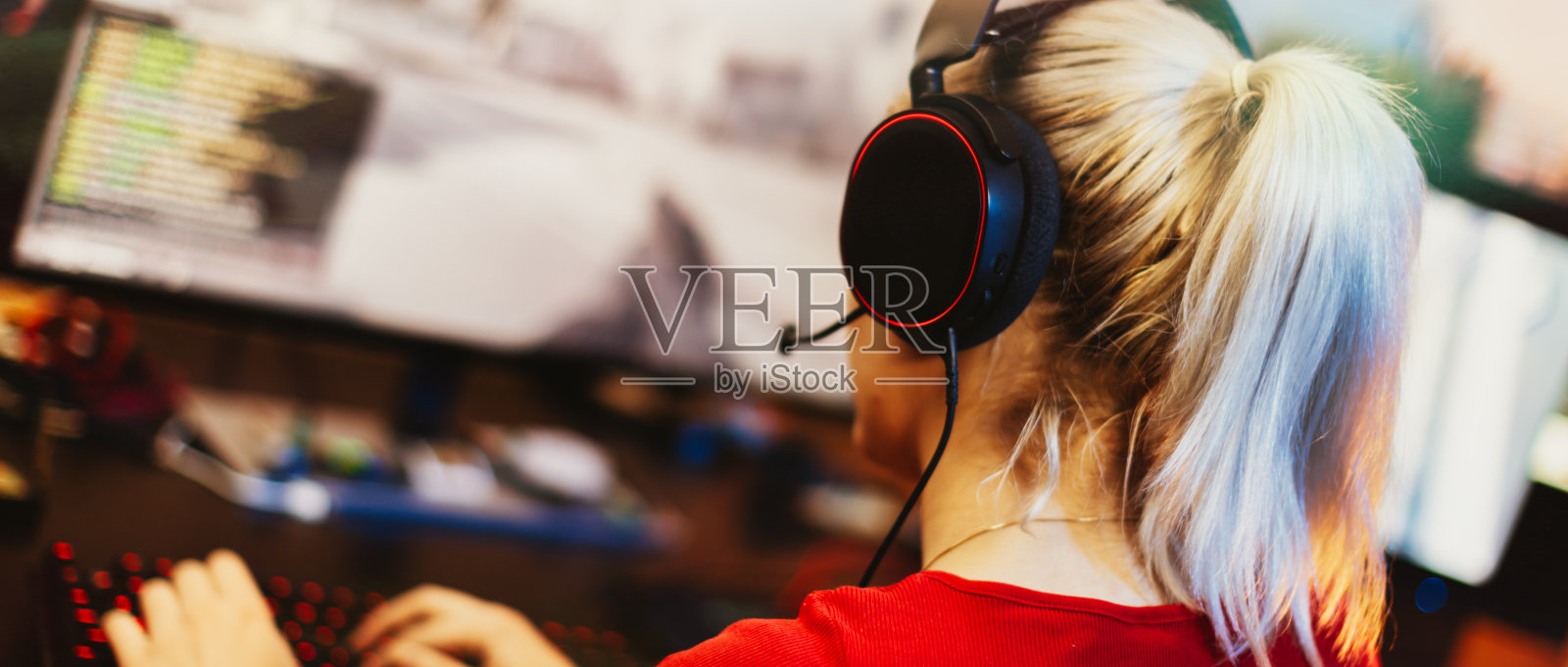 十几岁的女孩在他的暗室里用桌面电脑玩多人游戏照片摄影图片