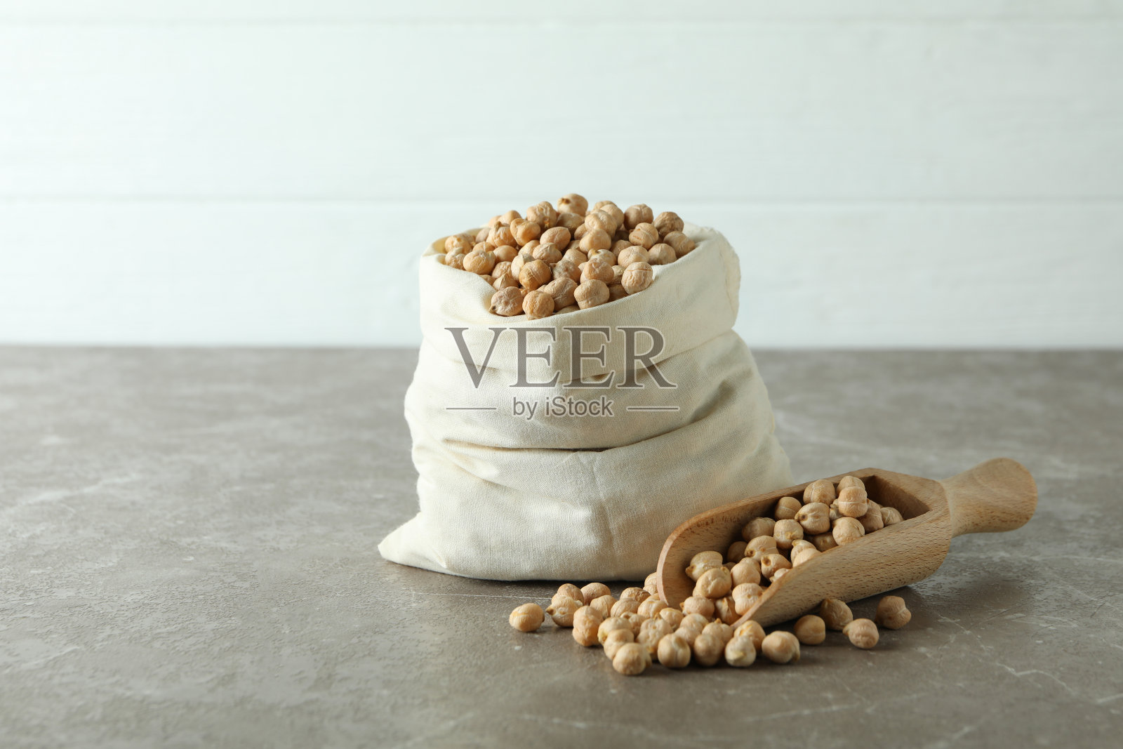 灰色的桌子上放着袋装鹰嘴豆照片摄影图片