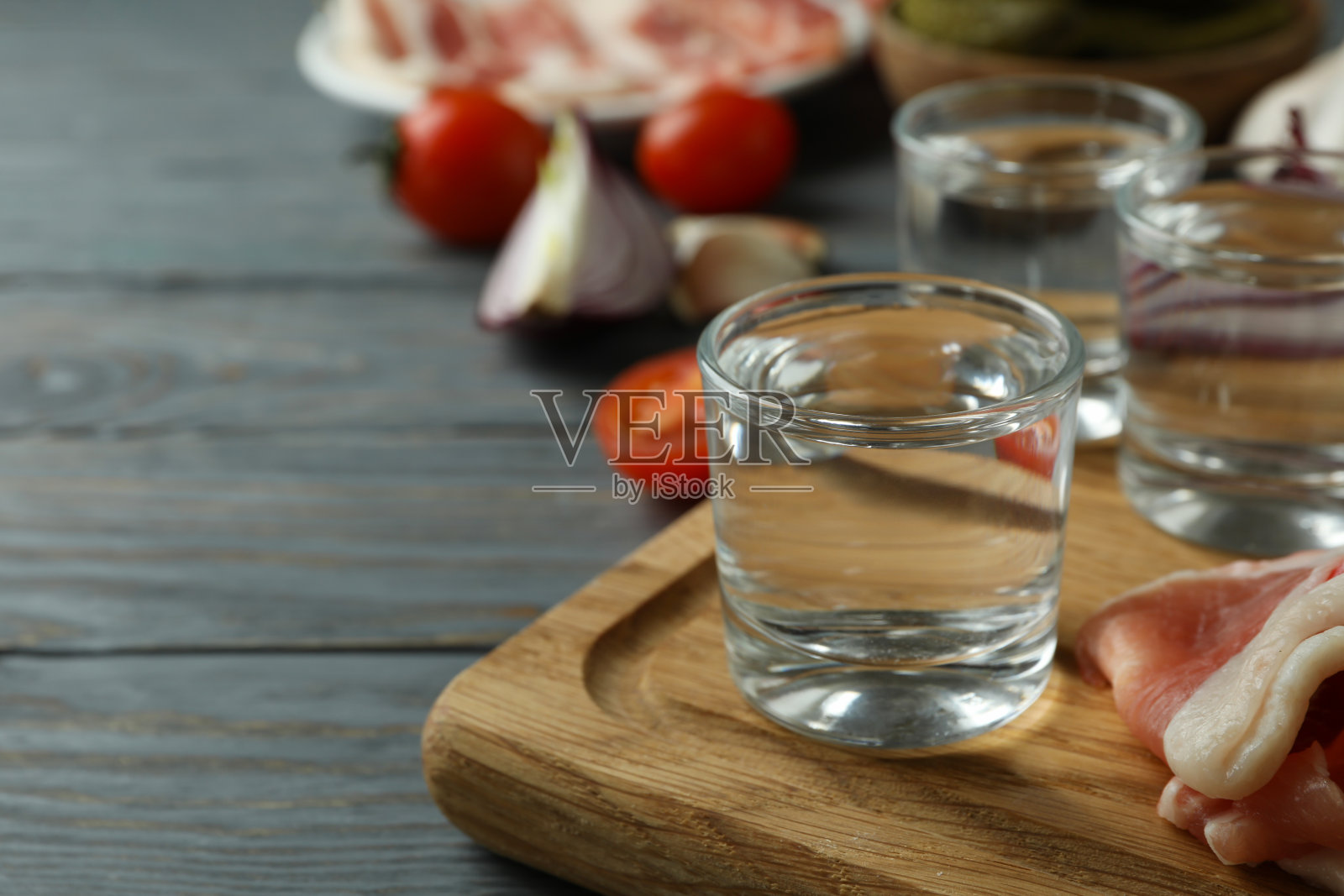 灰色木质背景下的伏特加和美味小吃的镜头照片摄影图片