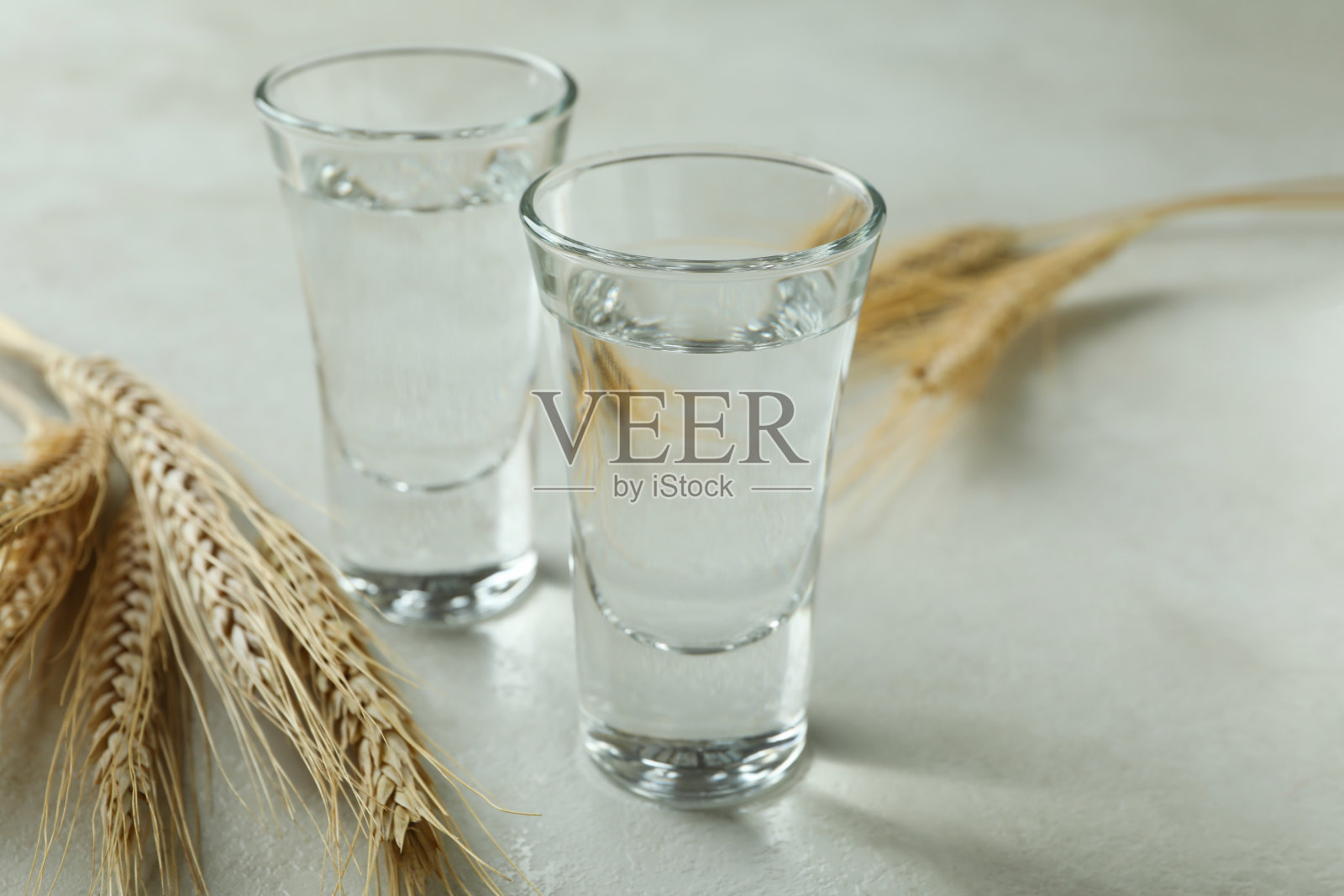 白色纹理的桌子上放着伏特加和小穗照片摄影图片