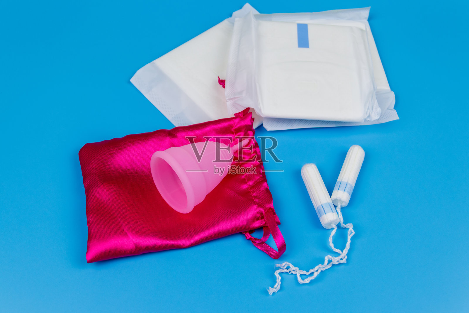 卫生棉，卫生棉条，月经杯，蓝色背景。关键日子、月经、女性卫生的概念照片摄影图片