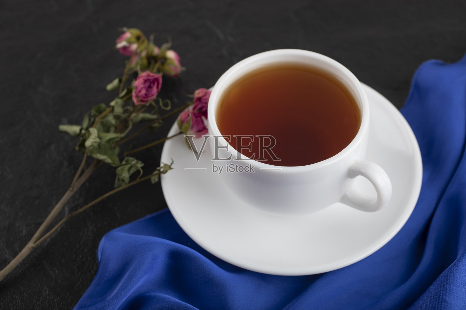 干玫瑰和一杯热茶在黑色的背景照片摄影图片