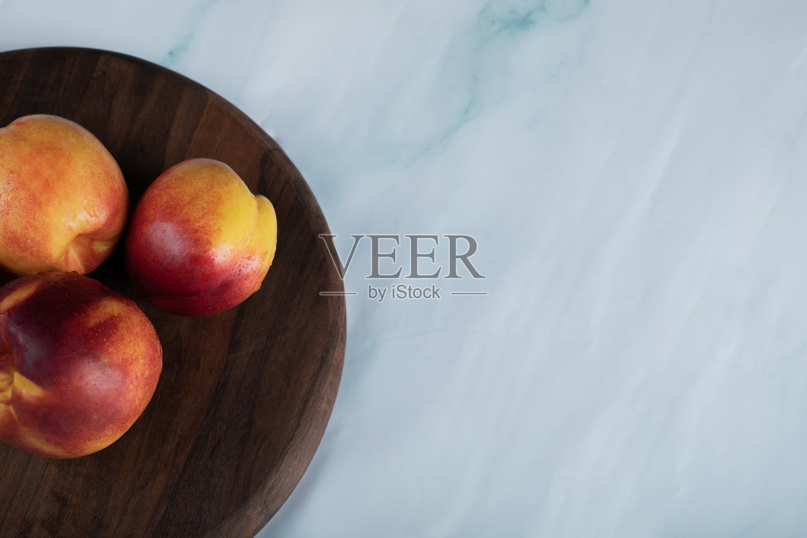 桌上的木板上放着红色和黄色的桃子照片摄影图片