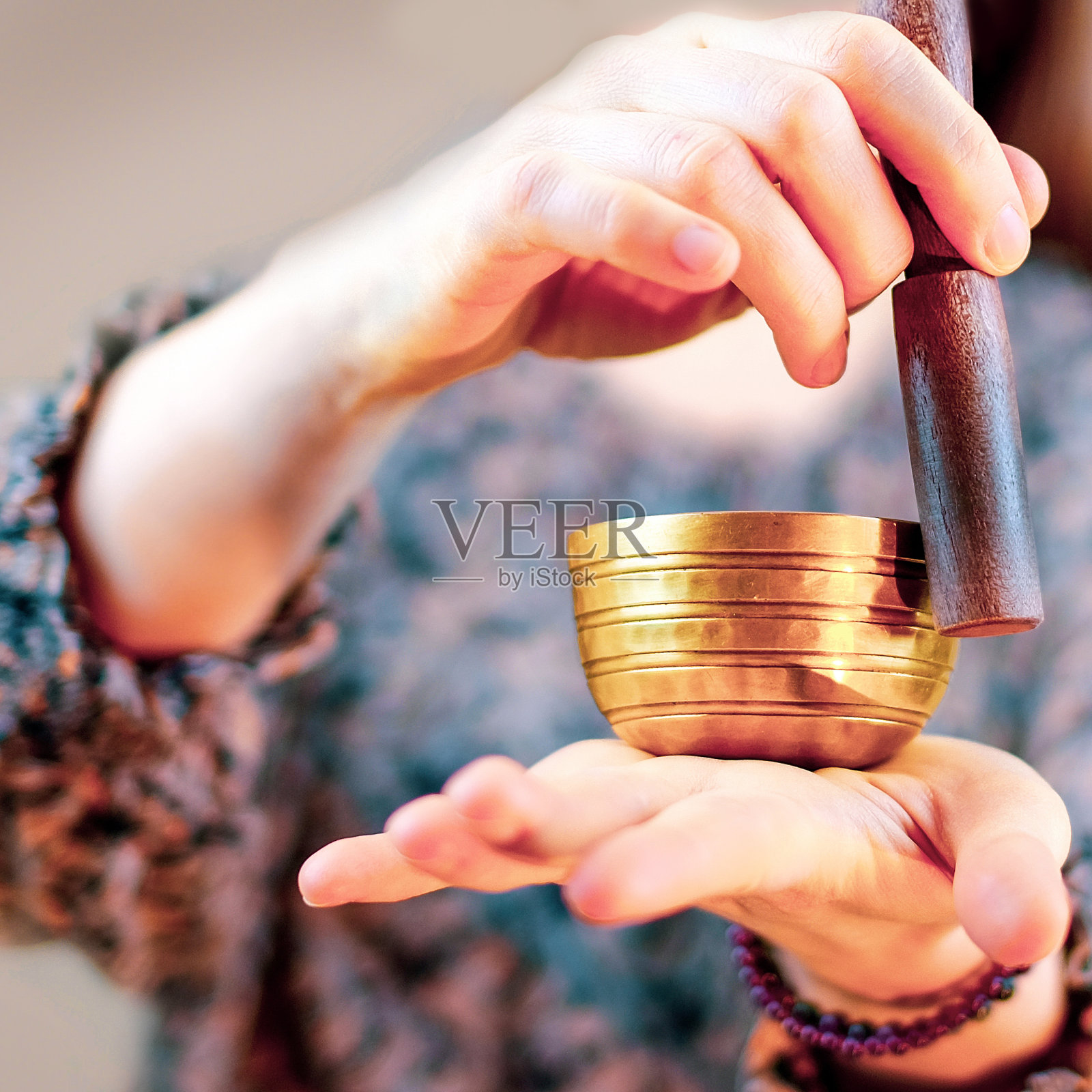 一个女人在玩一个藏族的唱歌碗照片摄影图片