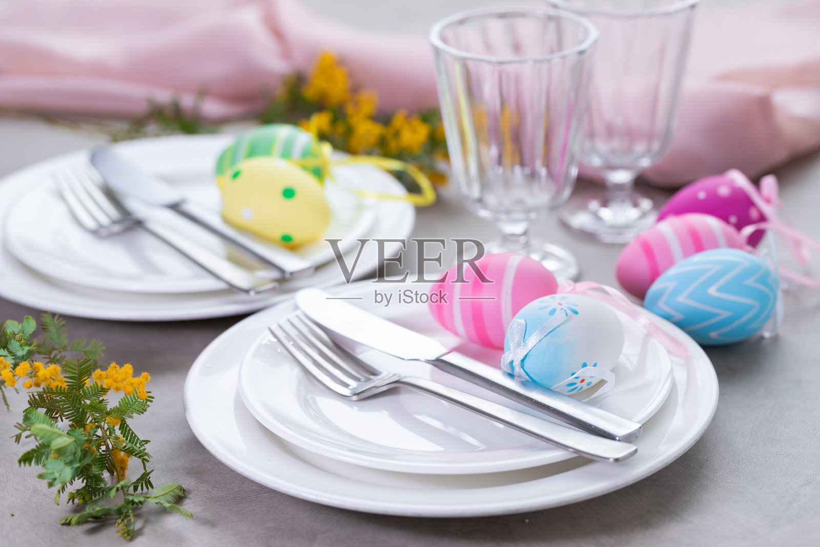 复活节餐桌上摆放含羞草花和餐具。节日的背景照片摄影图片