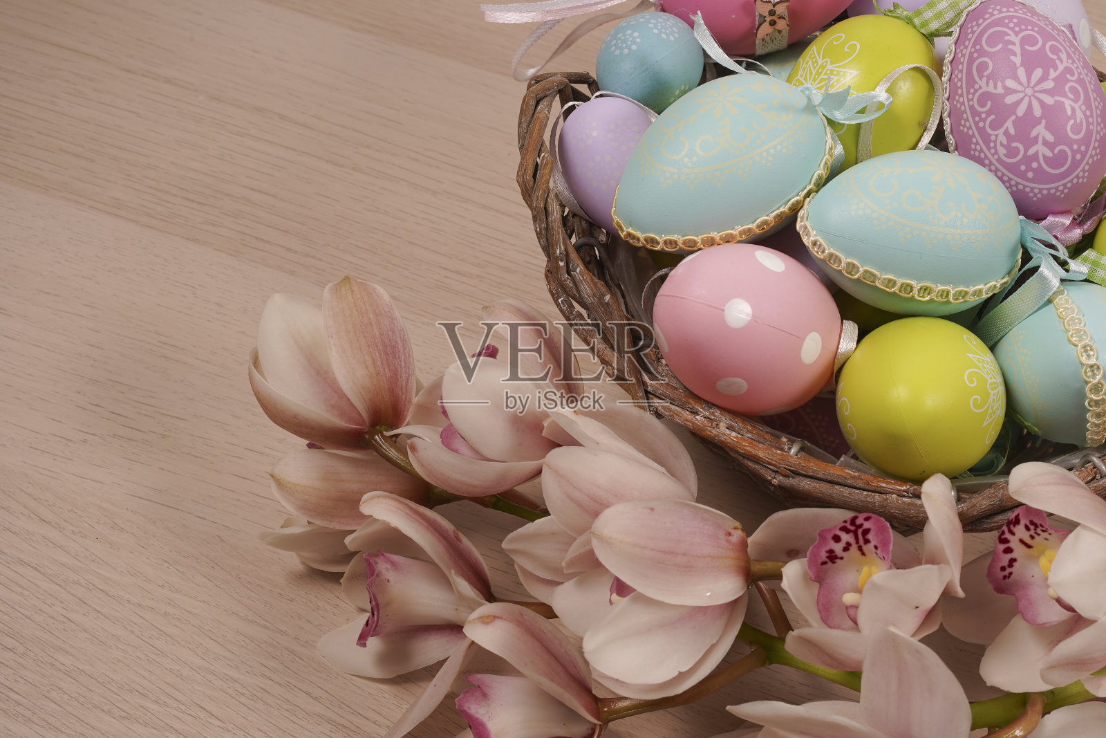 复活节彩蛋放在篮子里，放在木桌的背景上。照片摄影图片