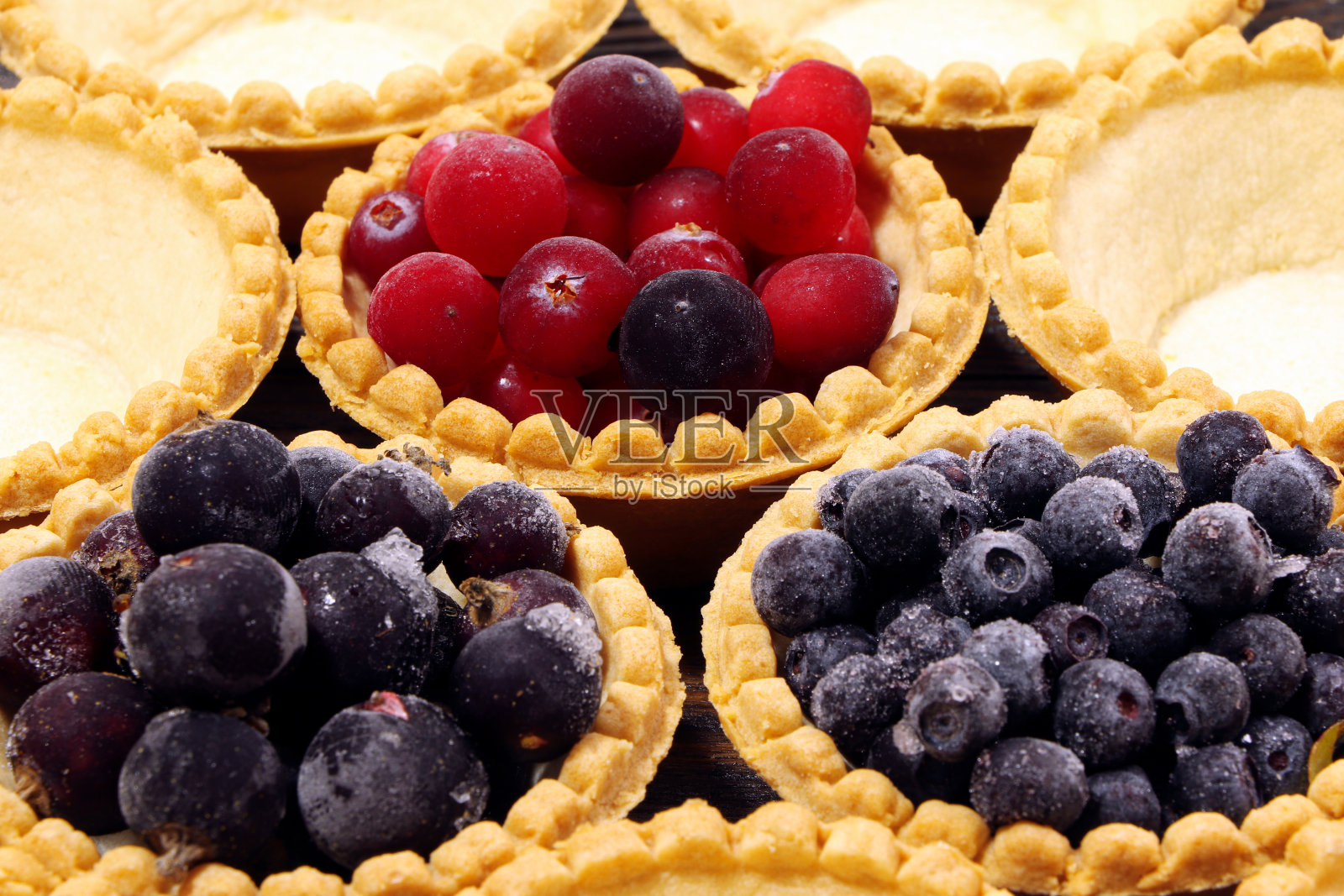 美味的果馅饼，搭配不同的浆果，蔓越莓，越桔，黑醋栗。贝瑞小果馅饼。蛋糕和浆果。甜点和浆果。木制背景。健康食品,维生素。照片摄影图片