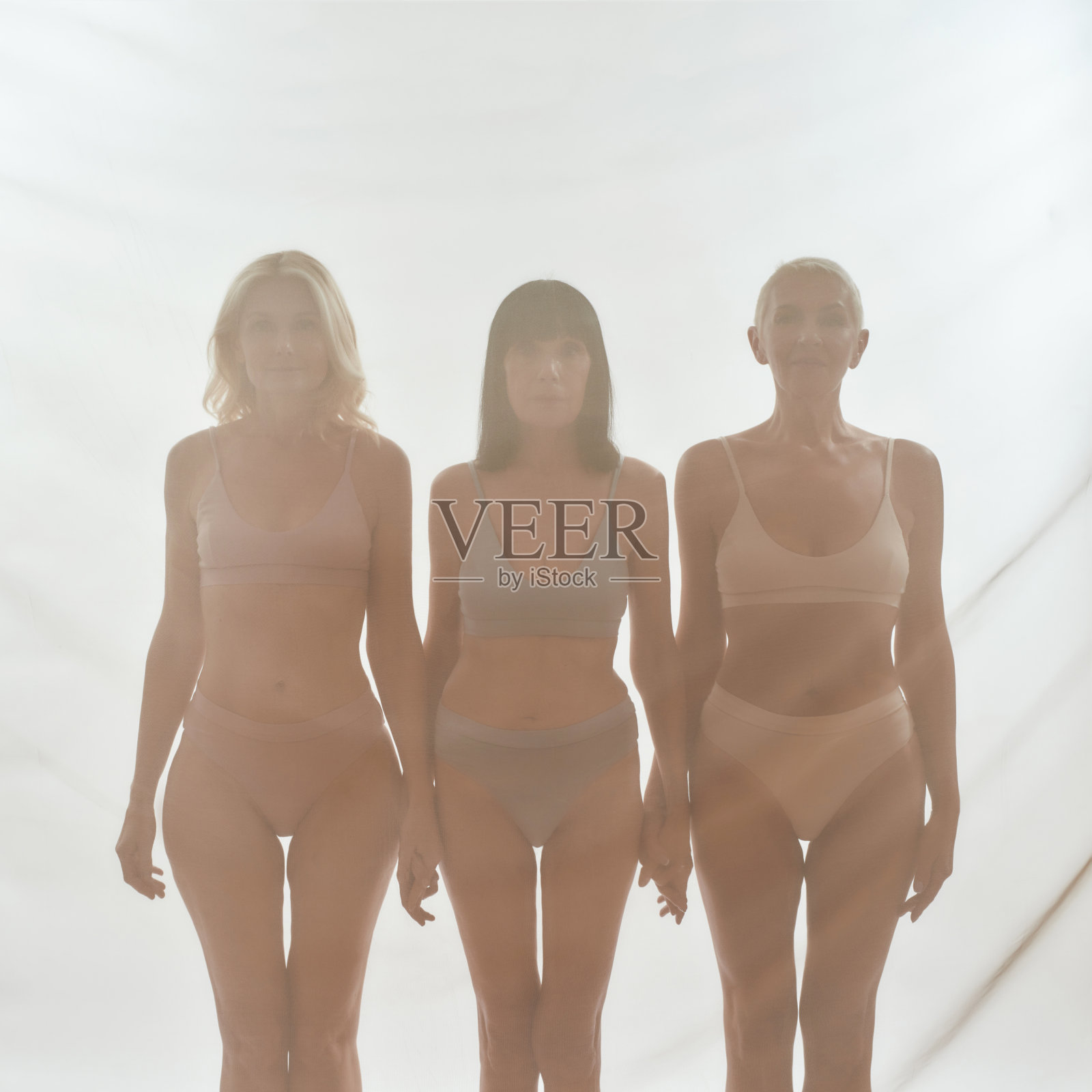 女人们在幕布后面手拉手照片摄影图片