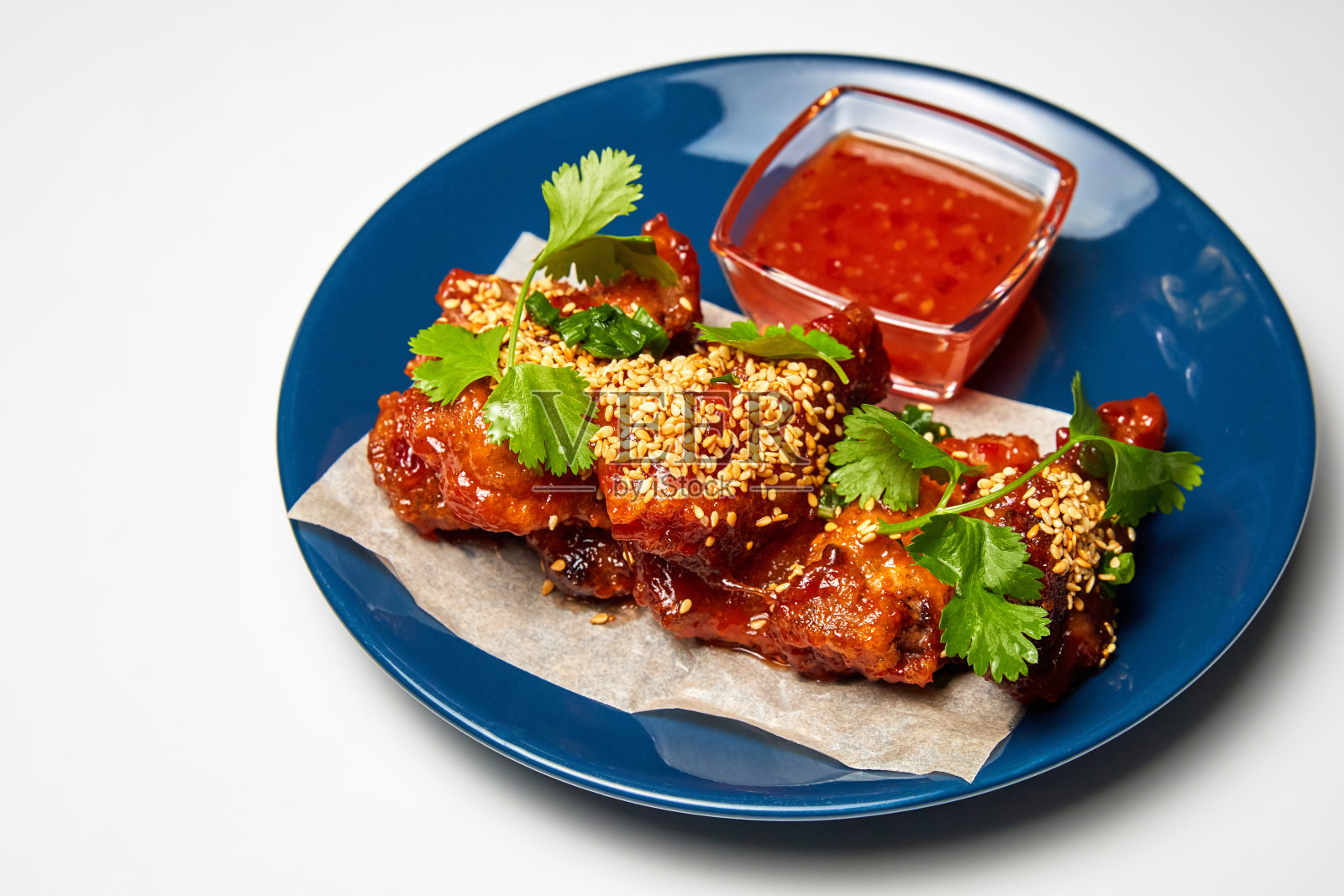 芝麻炸鸡翅配酱汁和欧芹。特写,有选择性的重点照片摄影图片