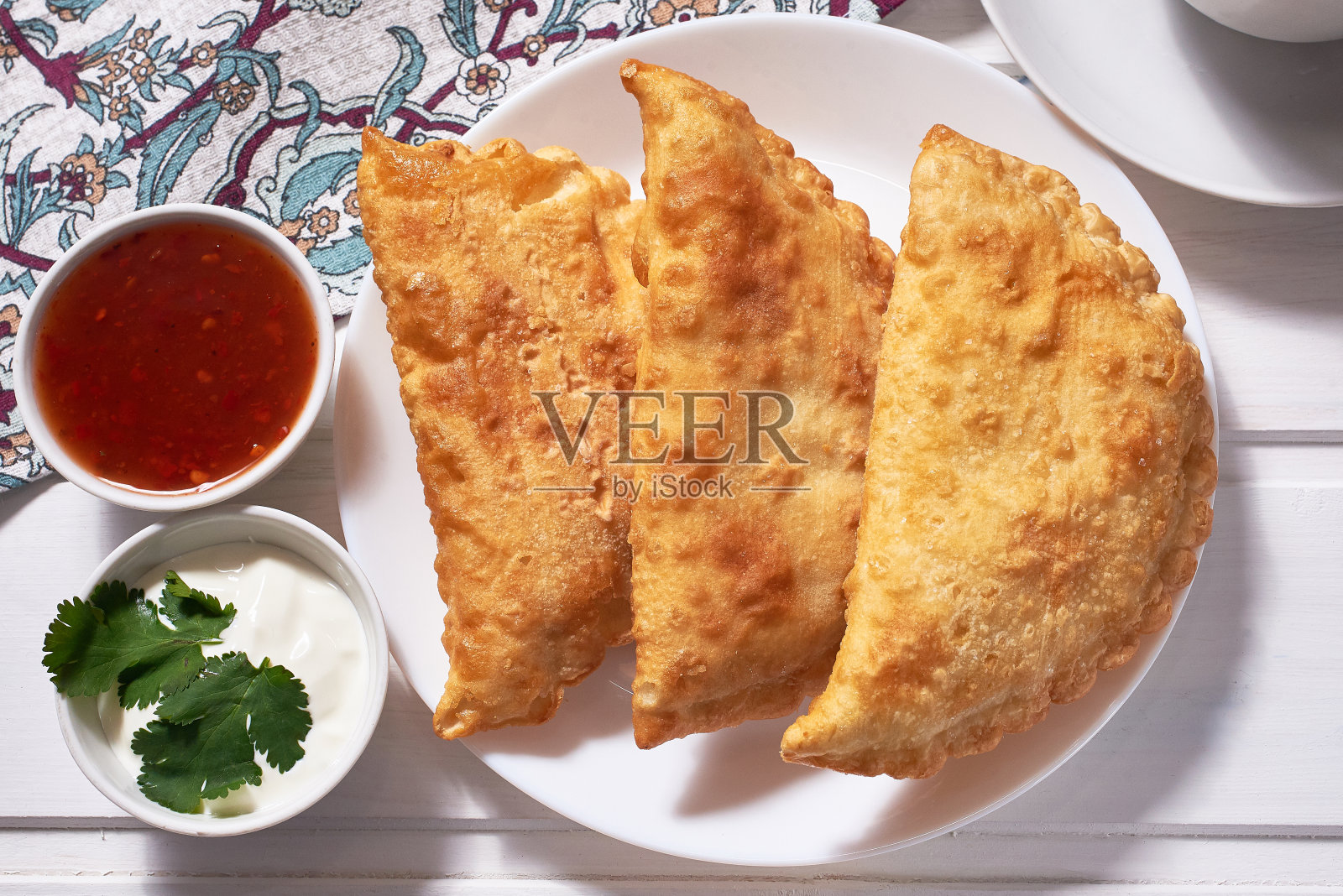 美味的烤乳酪(带肉的馅饼)，配上酱汁，放在白色的木质背景上。俯视图照片摄影图片