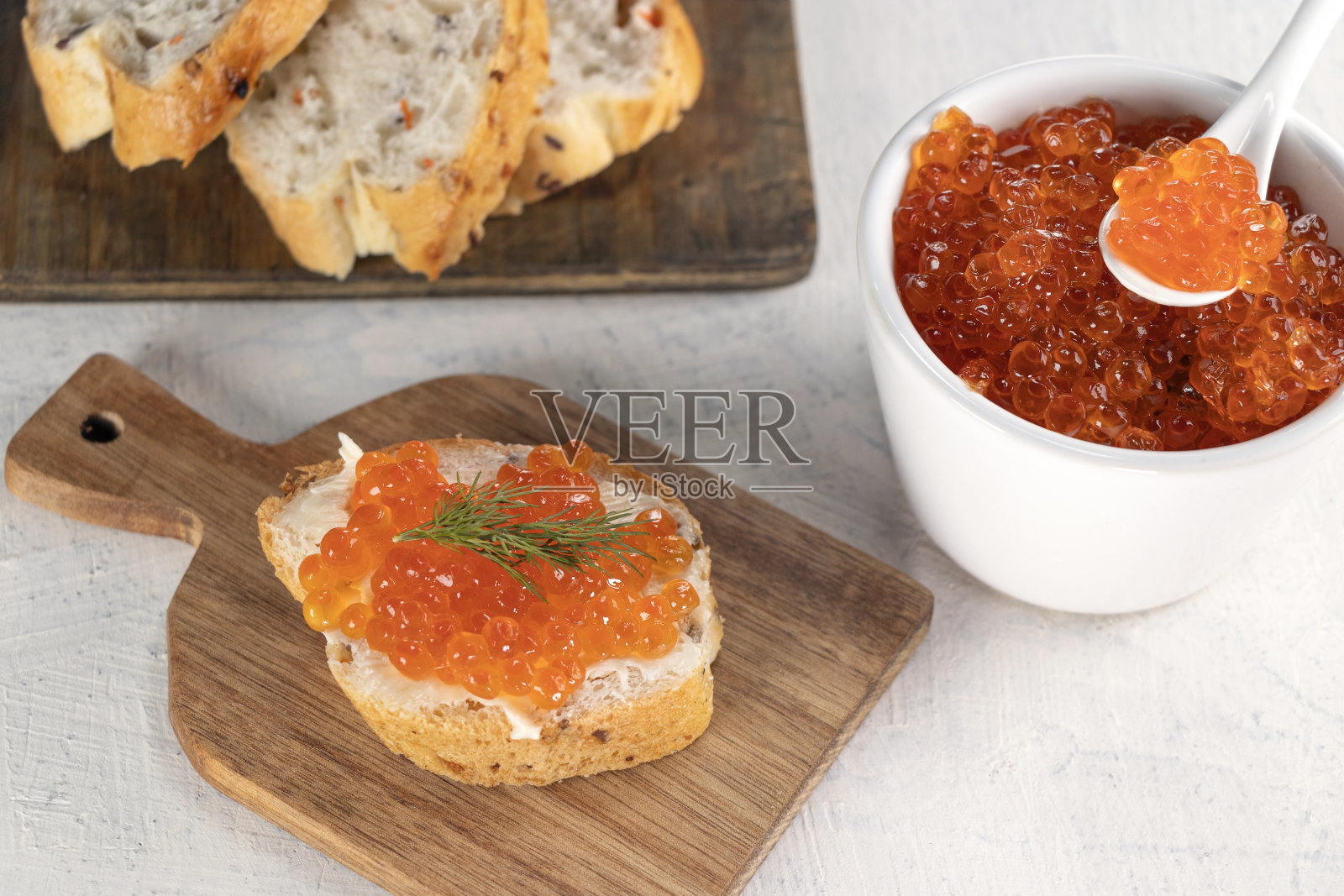 法棍面包，红鱼子酱，白底莳萝。烹饪过程。用红鱼子酱做开胃菜的食谱照片摄影图片
