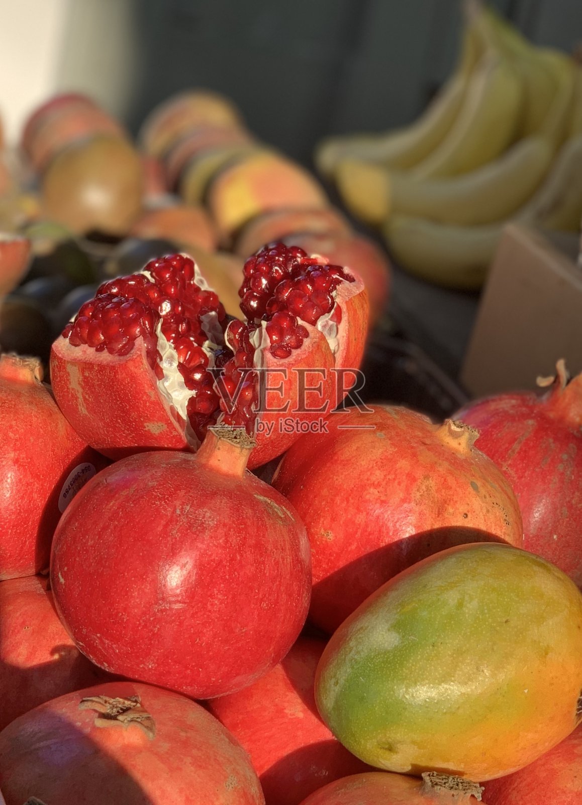 市场摊位上的水果：香蕉、石榴、芒果照片摄影图片