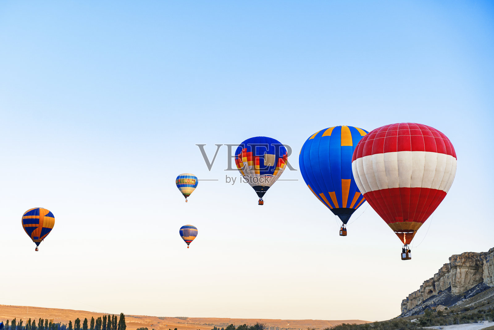 彩色的气球在晴朗的天空中飞行在巨大的白色的山照片摄影图片