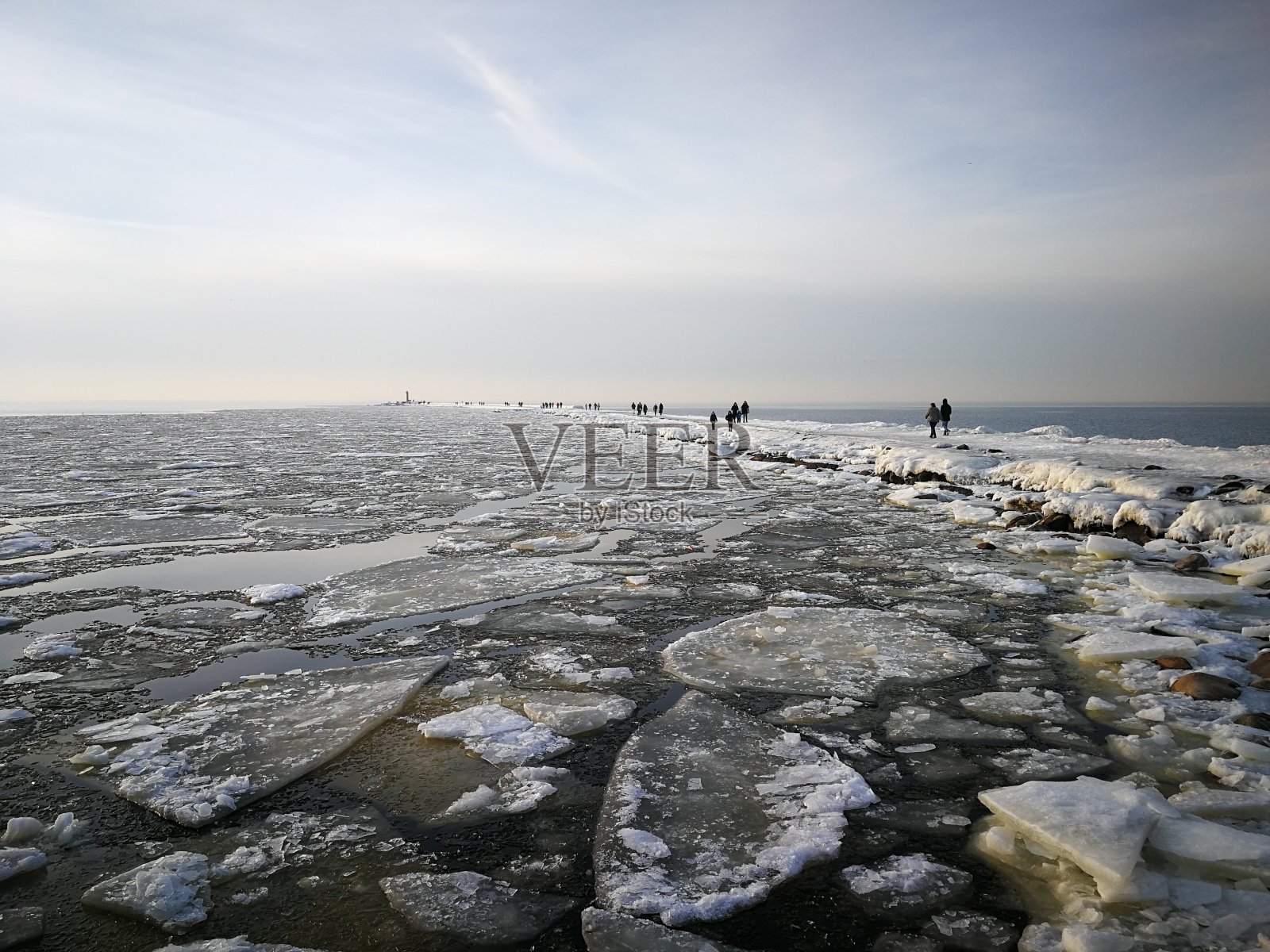 有一座被雪覆盖的灯塔的码头照片摄影图片