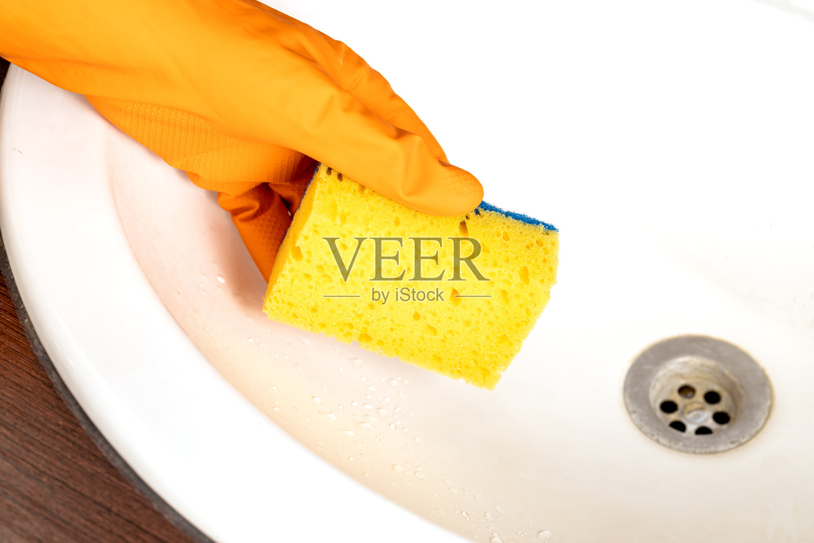 水槽清洗的概念。橡胶手套和洗碗海绵照片摄影图片