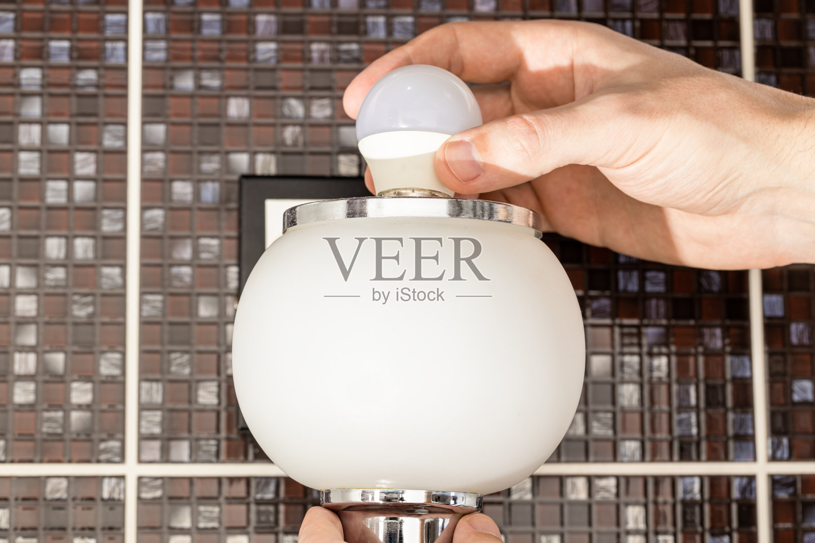 灯泡更换概念。更换led灯泡的杂工或合同工。近距离照片摄影图片