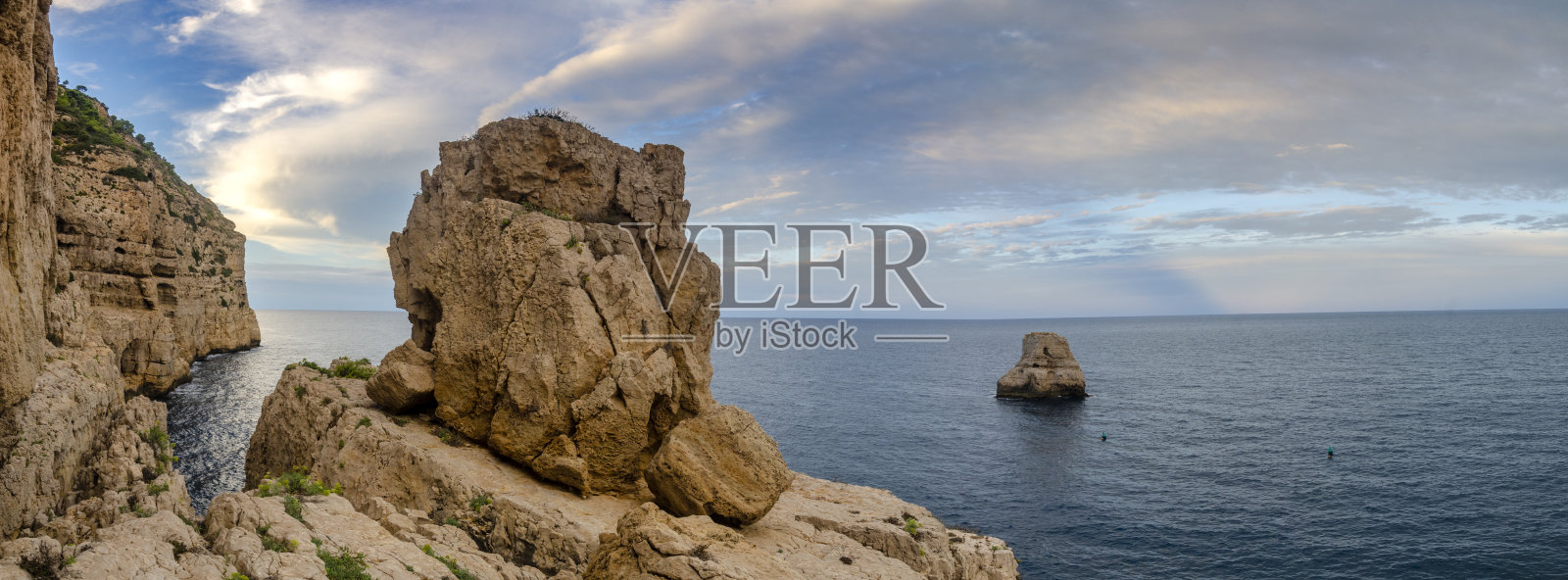 日落时从悬崖上看到的全景。海面上出现了一个小岛照片摄影图片